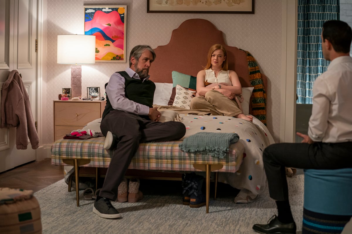 Succession stars Alan Ruck and Sarah Snook sit on the bed