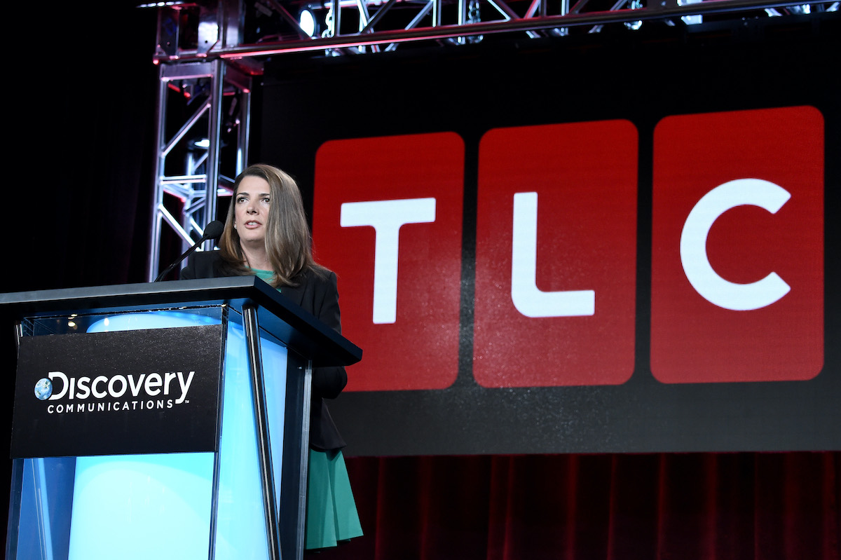 General Manager, TLC, Nancy Daniels speaking in front of a TLC logo