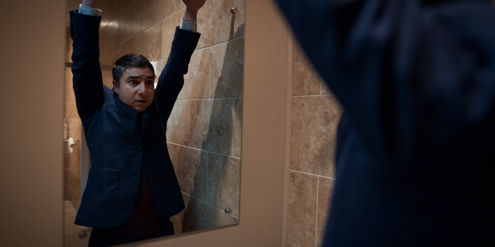 Nate Shelley, played by Nick Mohammed, raising his hands and looking in a mirror in a production still from 'Ted Lasso' Season 2