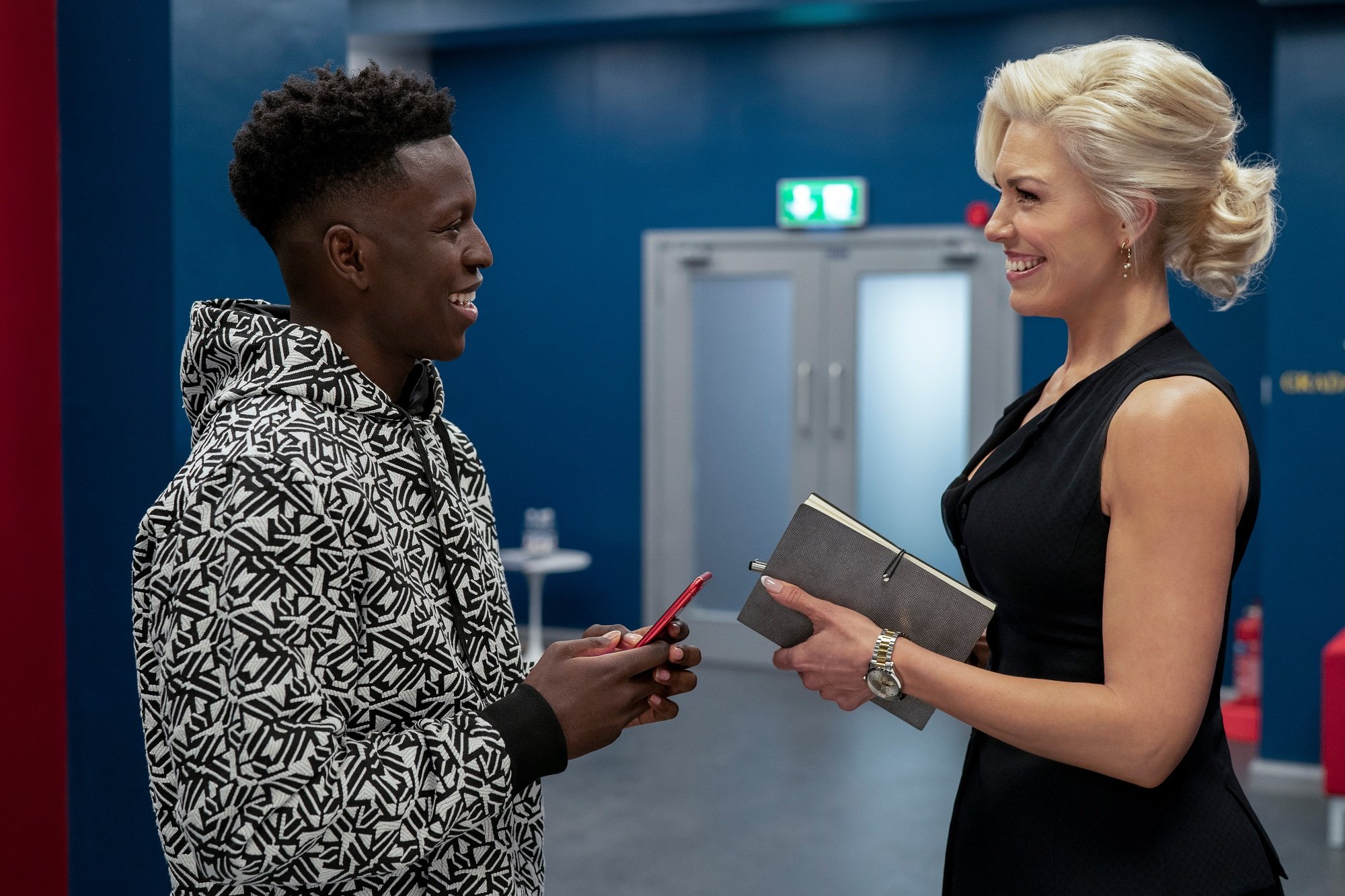 Sam Obisanya and Rebecca Welton stand in a hallway in 'Ted Lasso'