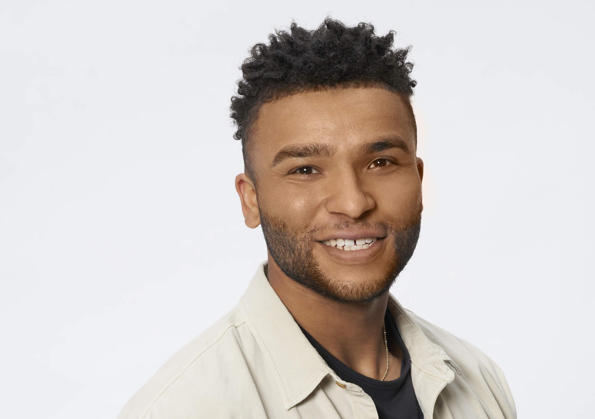 Daniel Tully in his headshot for the 'The Bachelorette' wearing a tan jacket and black tshirt.