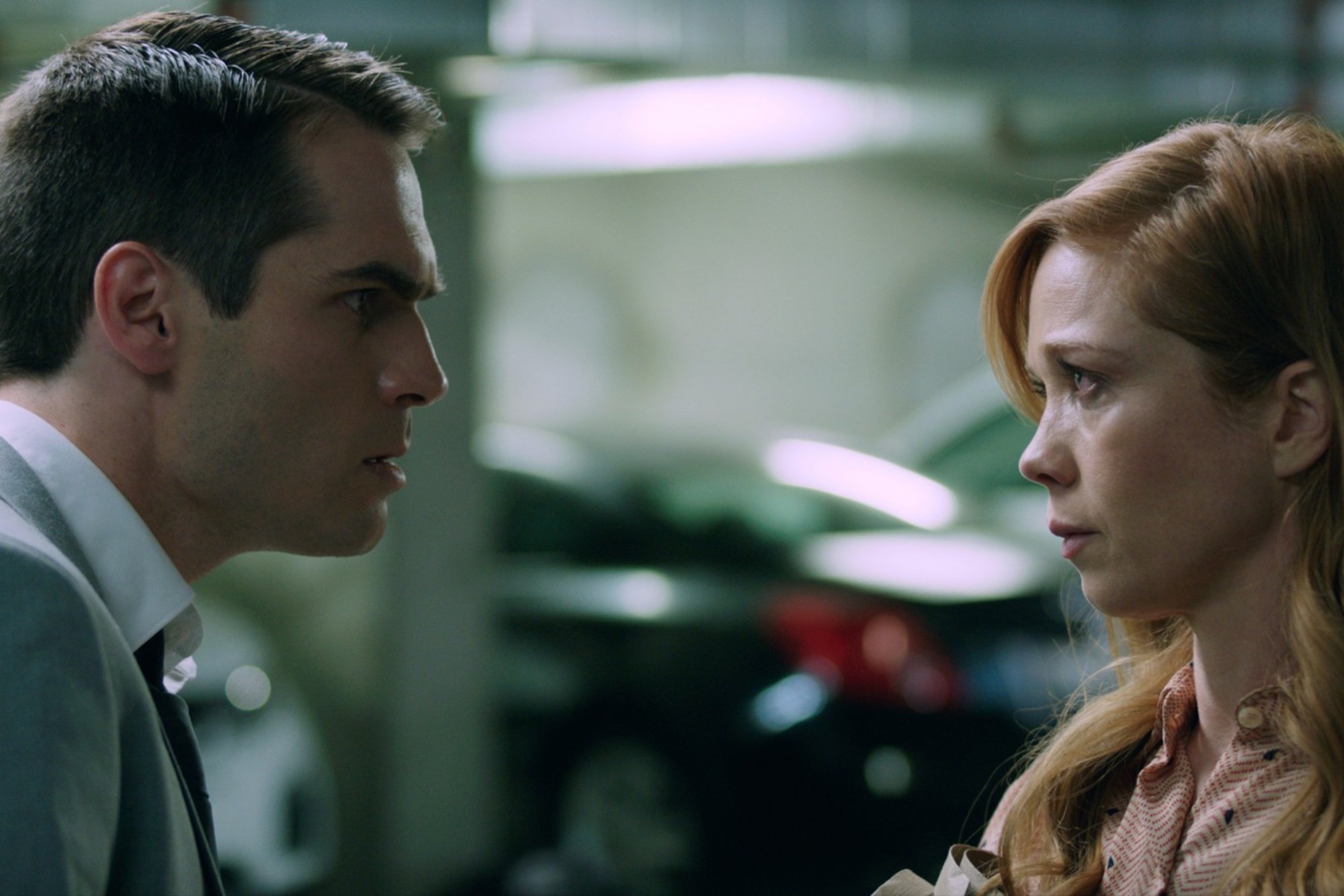 'The Beta Test' actors Jim Cummings as Jordan and Virginia Newcomb as Caroline looking intensely at each other in a parking lot