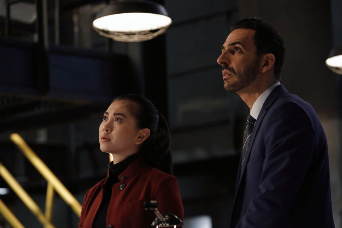 Two members of The Blacklist cast,Laura Sohn as Agent Alina Park and Amir Arison as Aram Mojtabai look up.