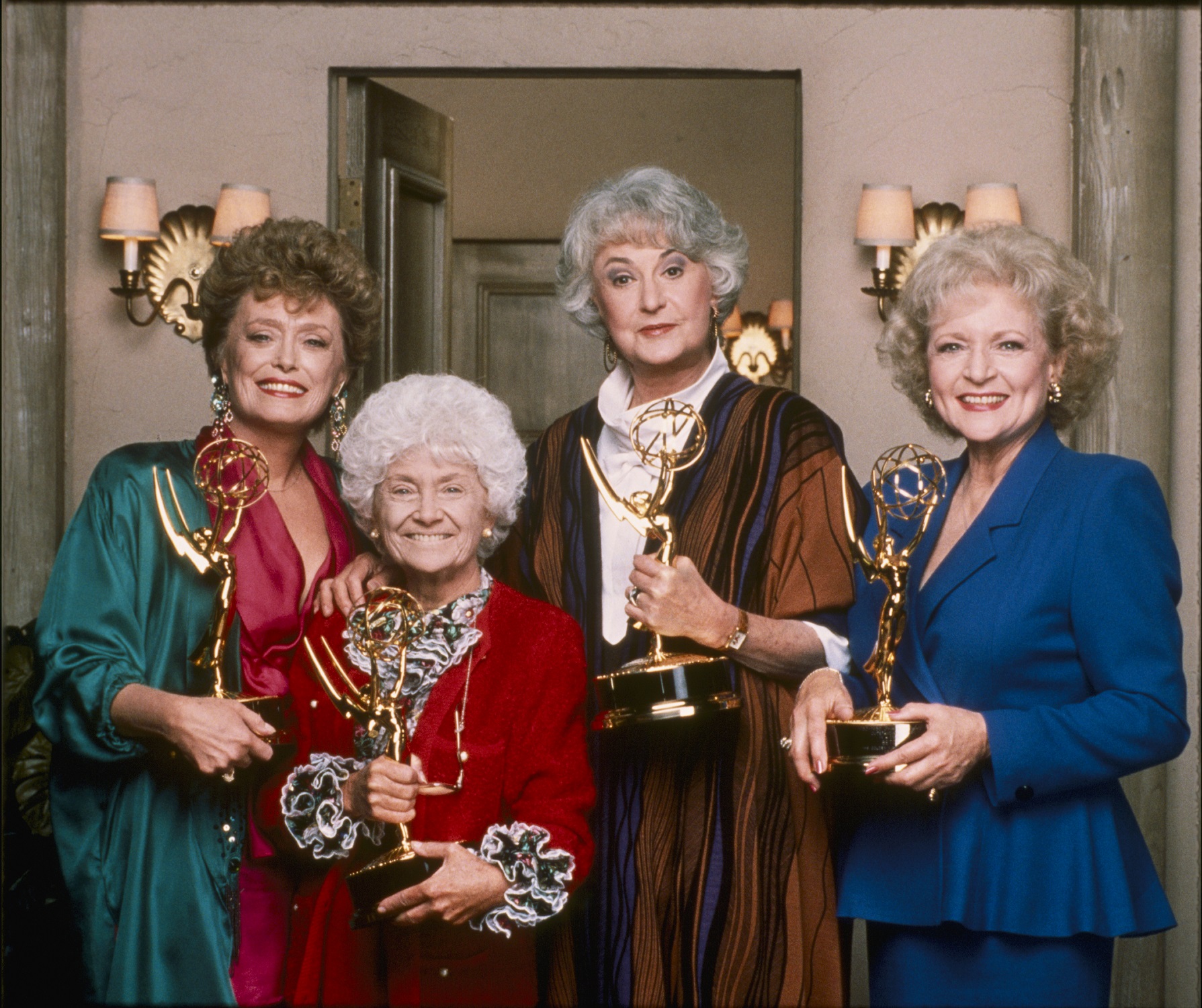 The cast of 'The Golden Girls' stand on set holding their Emmy Awards