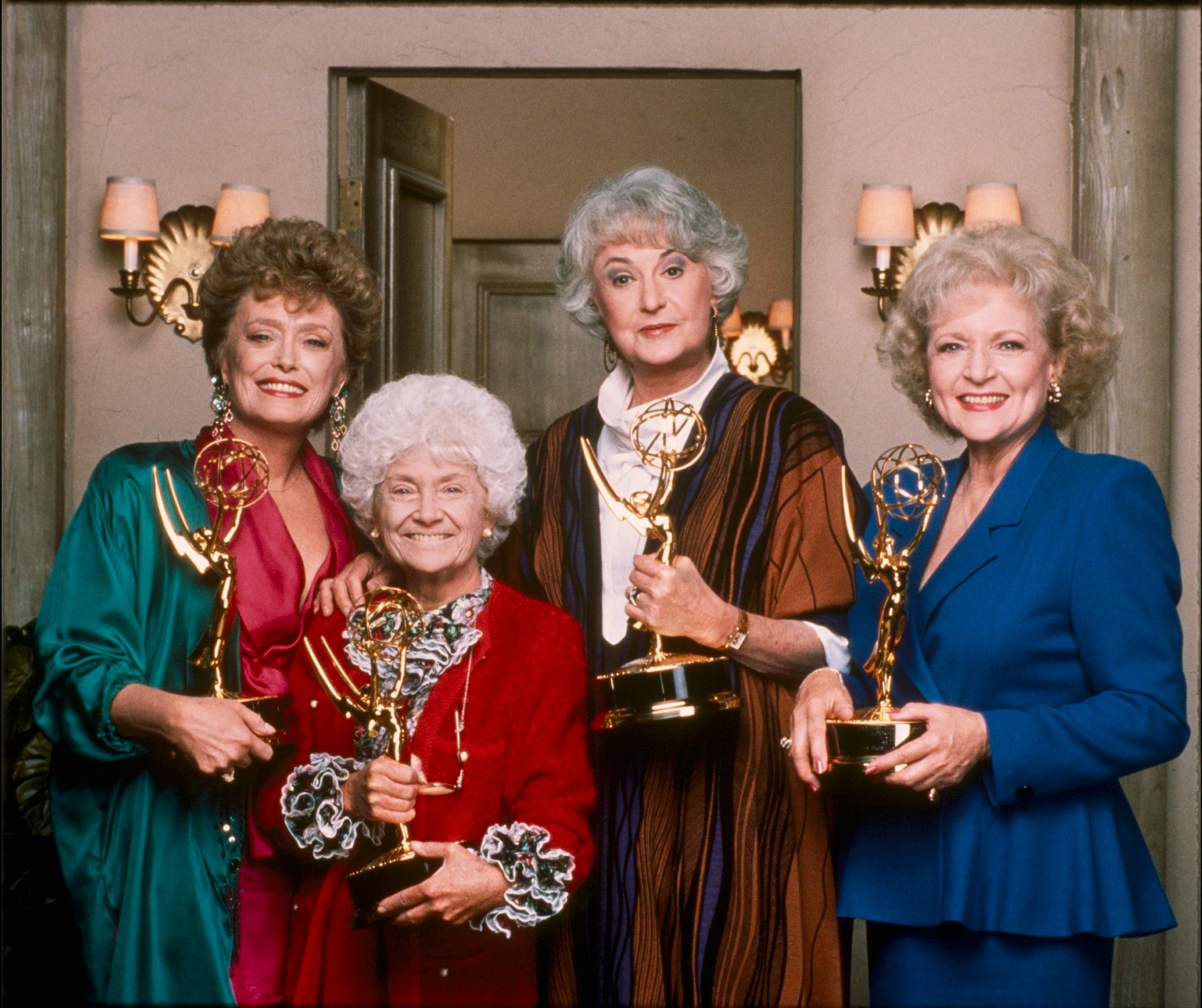 The cast of 'The Golden Girls' stand on set holding their Emmy Awards