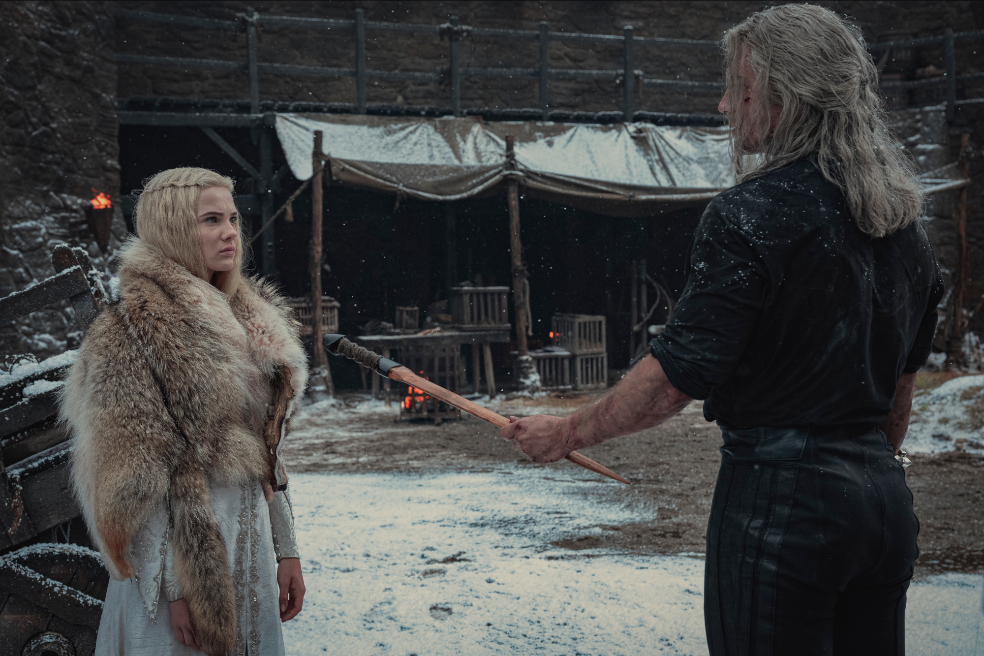 Freya Allen and Henry Cavill as Ciri and Geralt in 'The Witcher' Season 2. They're standing in the snow, and he's handing her a sword.