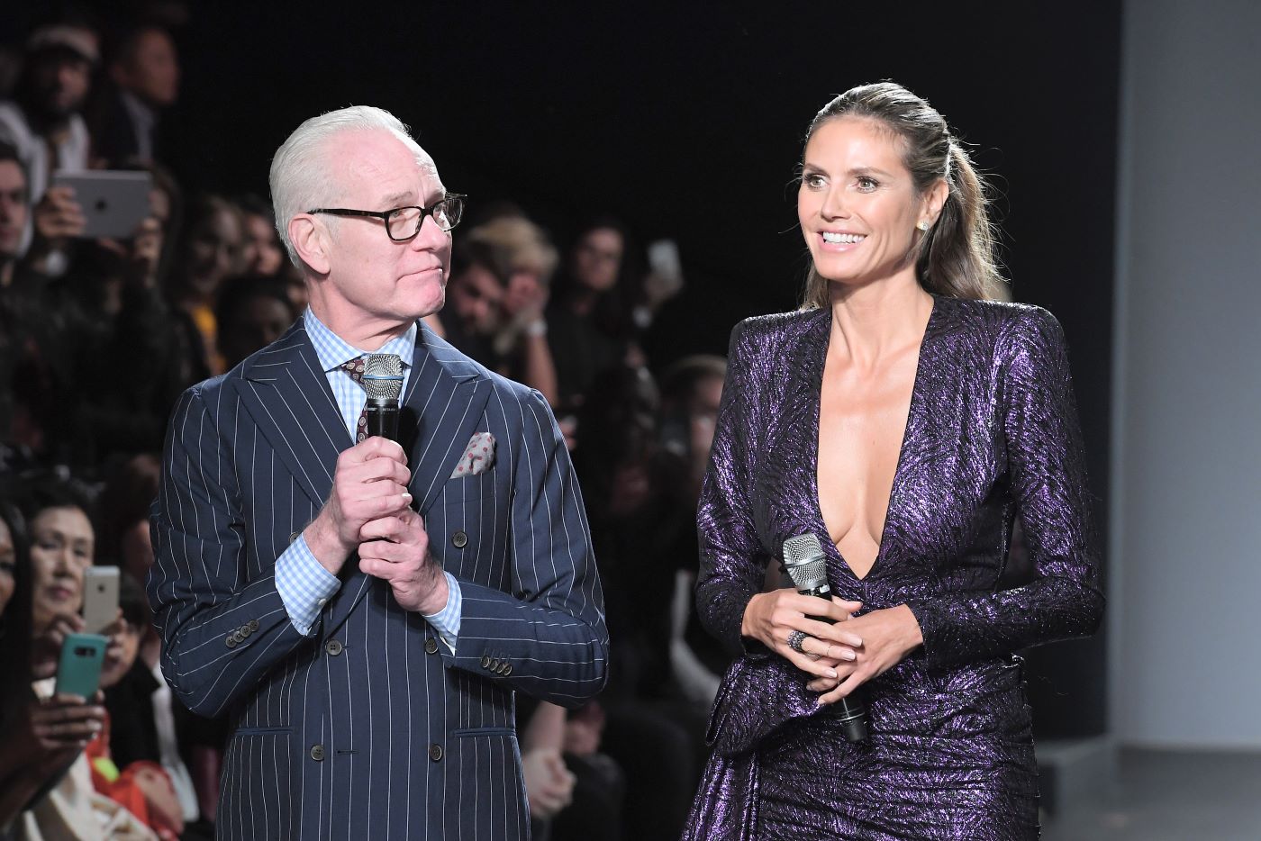 Former 'Project Runway' star Tim Gunn in a suit and Heidi Klum in a sparkly purple dress