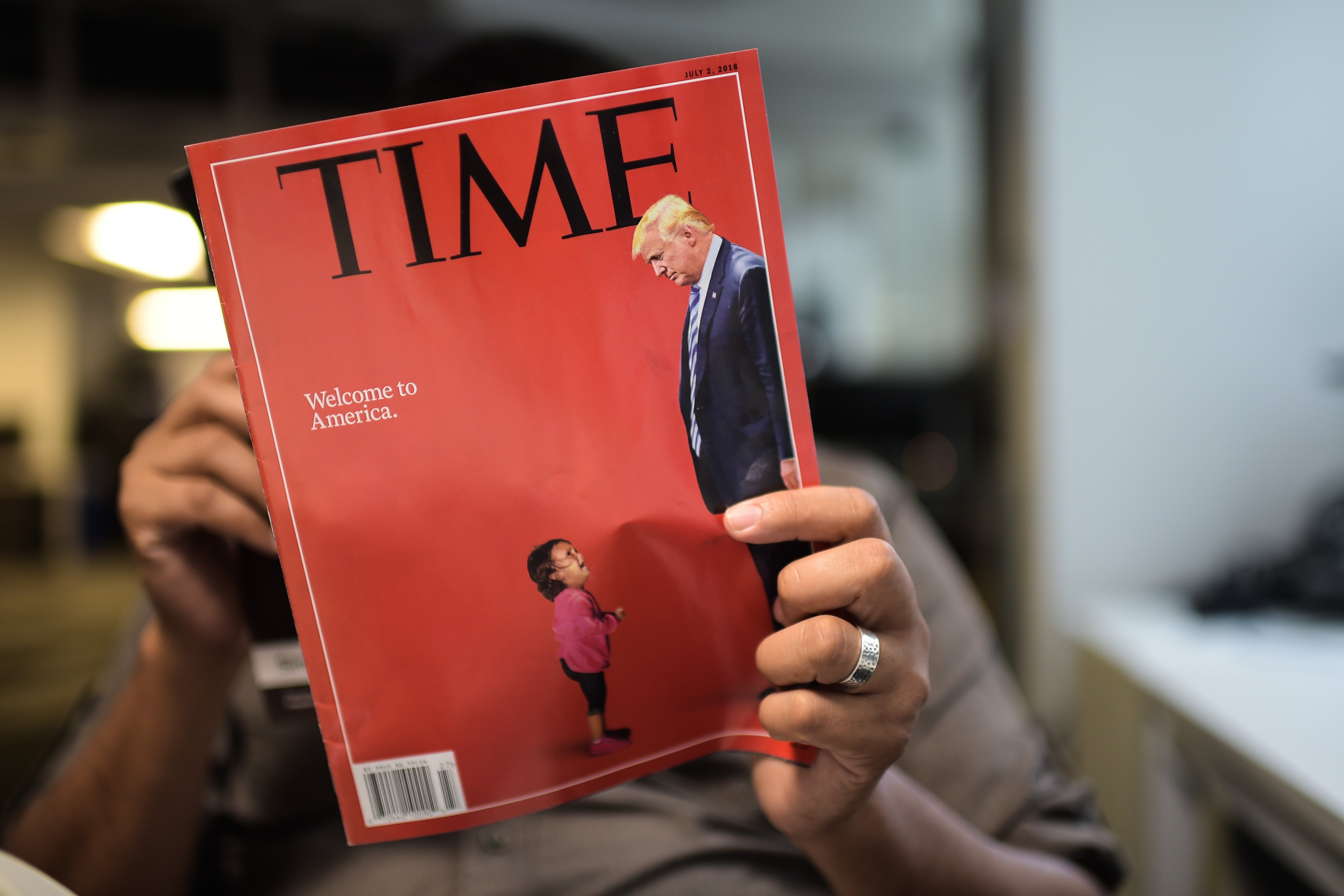 Person reading a June 2019 Time magazine with Donald Trump and crying child on cover