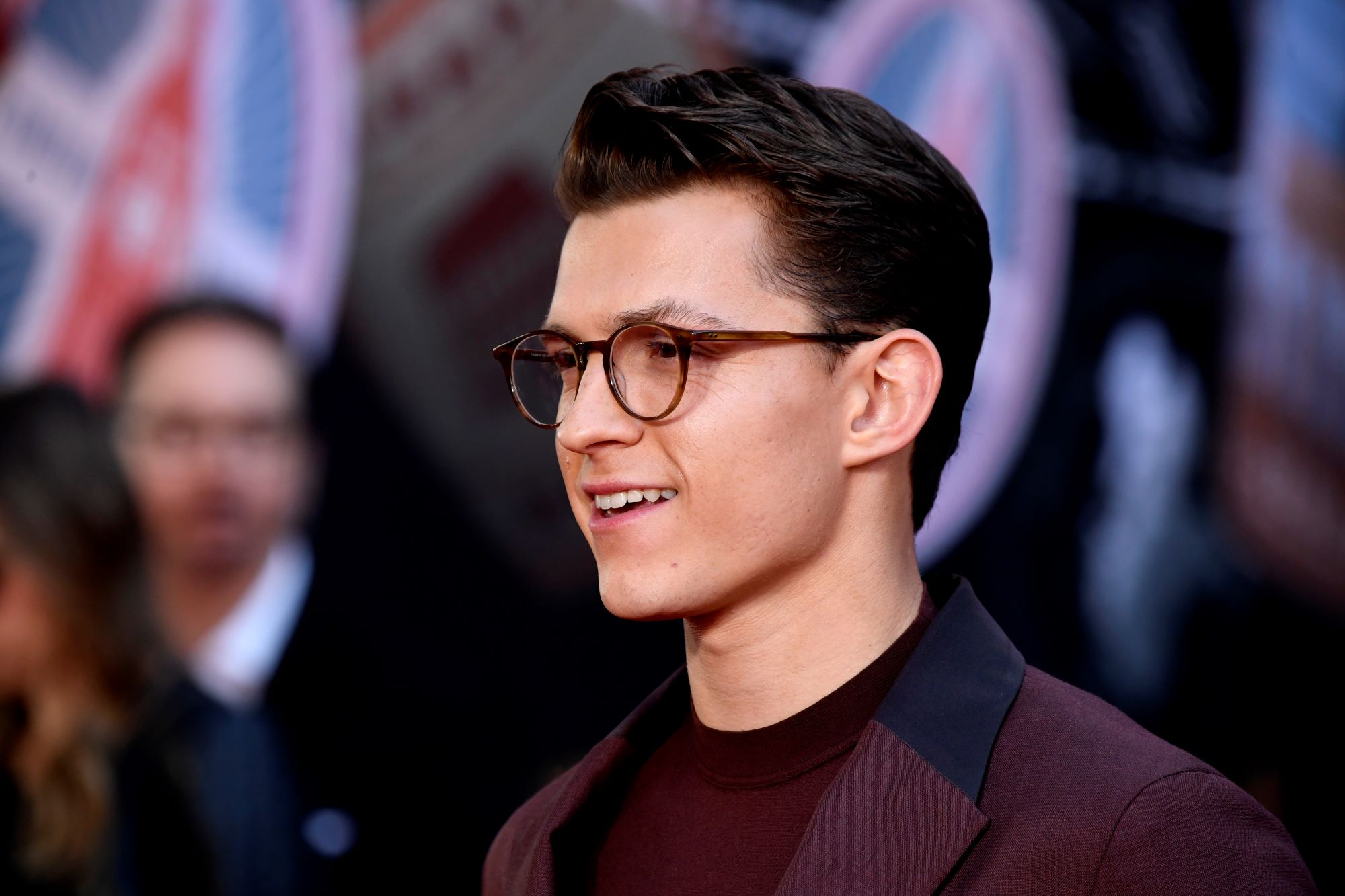 'Spider-Man: No Way Home' actor Tom Holland wears a maroon suit over a maroon shirt and a pair of glasses. A new poster for the film may confirm the return of Sandman.