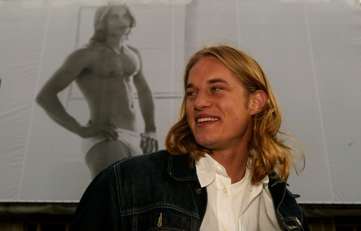 Travis Fimmel looks away from the camera, posing in front of his Calvin Klein billboard