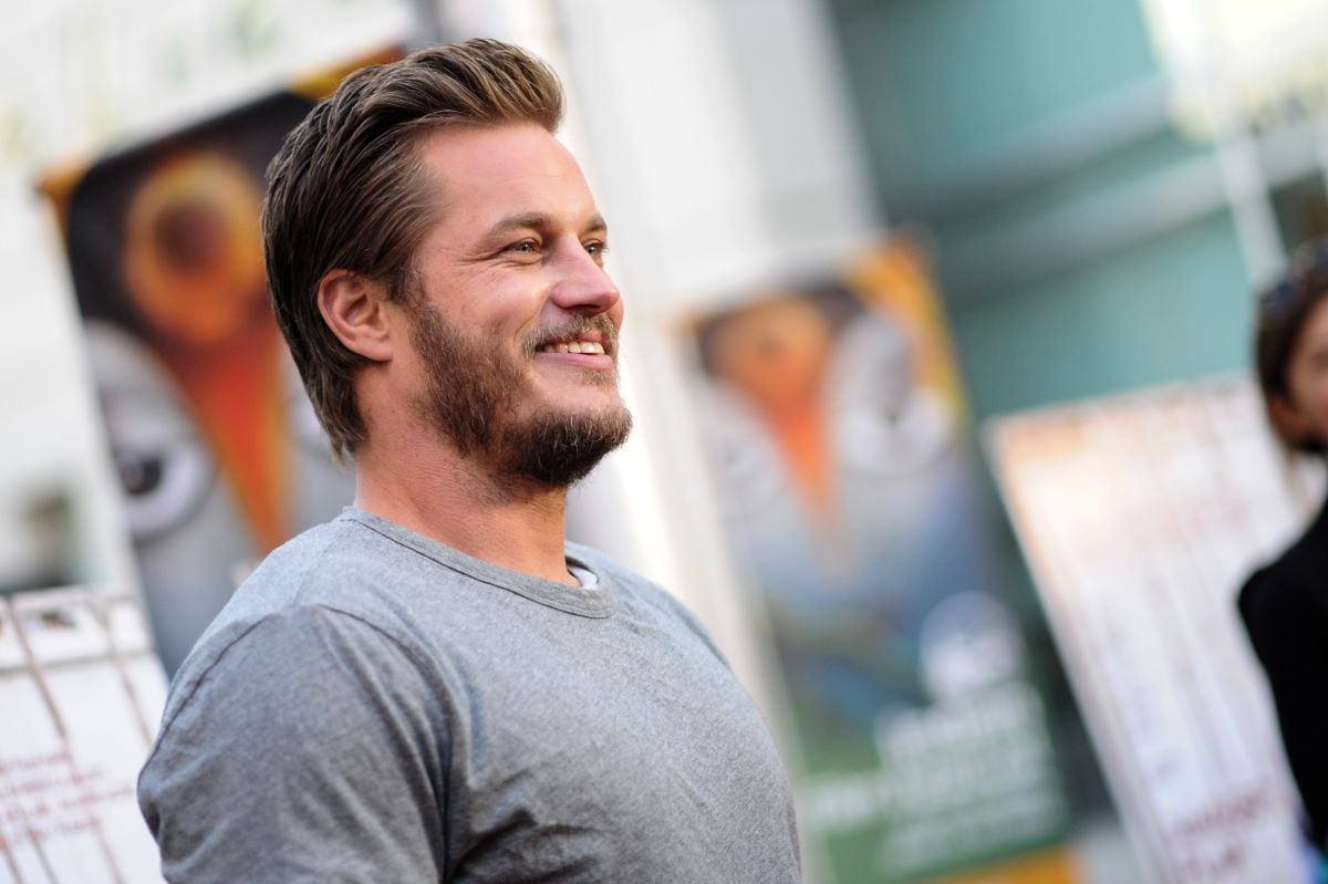Travis Fimmel smiling in gray shirt, pictured from side