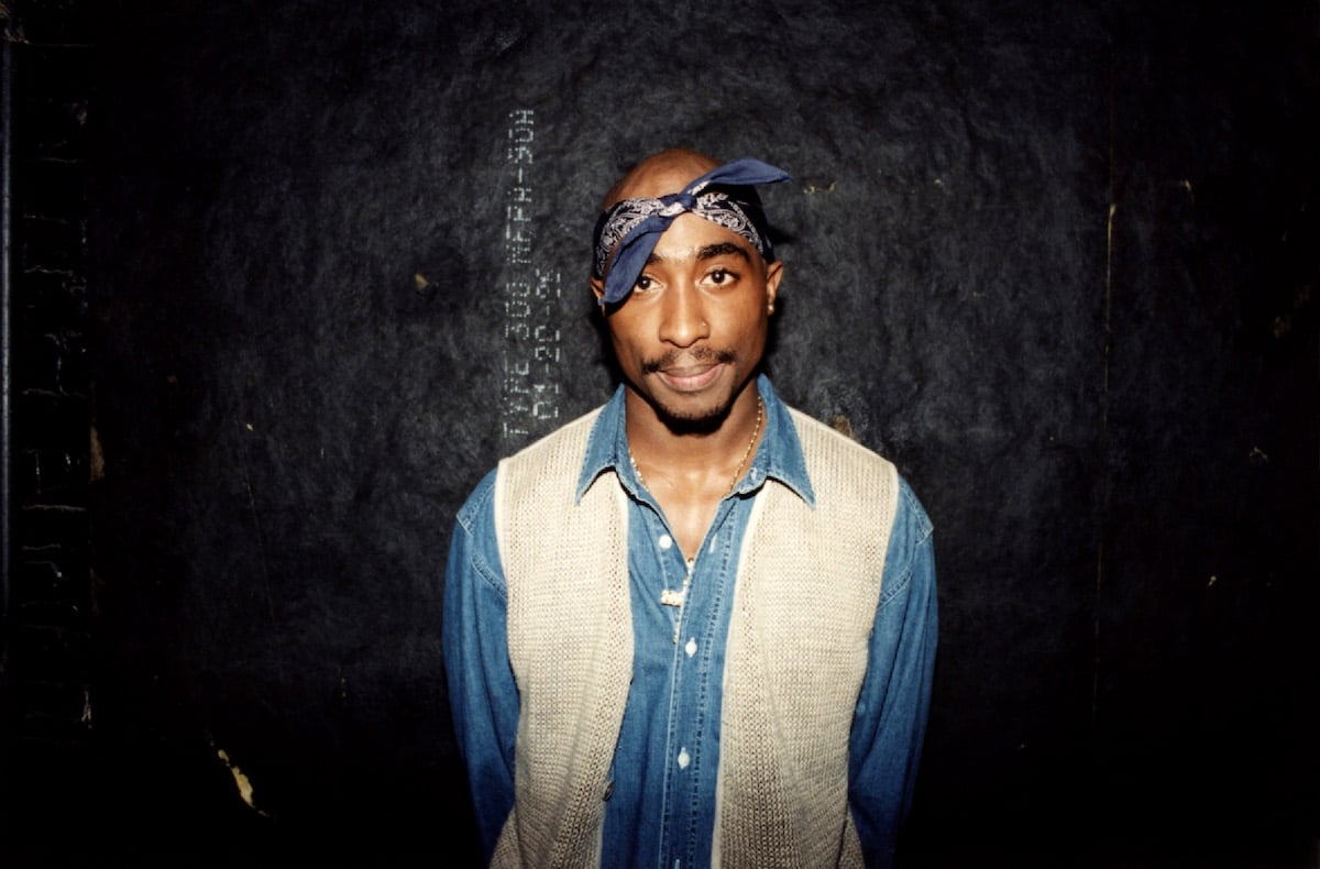 Tupac Shakur standing on a black background