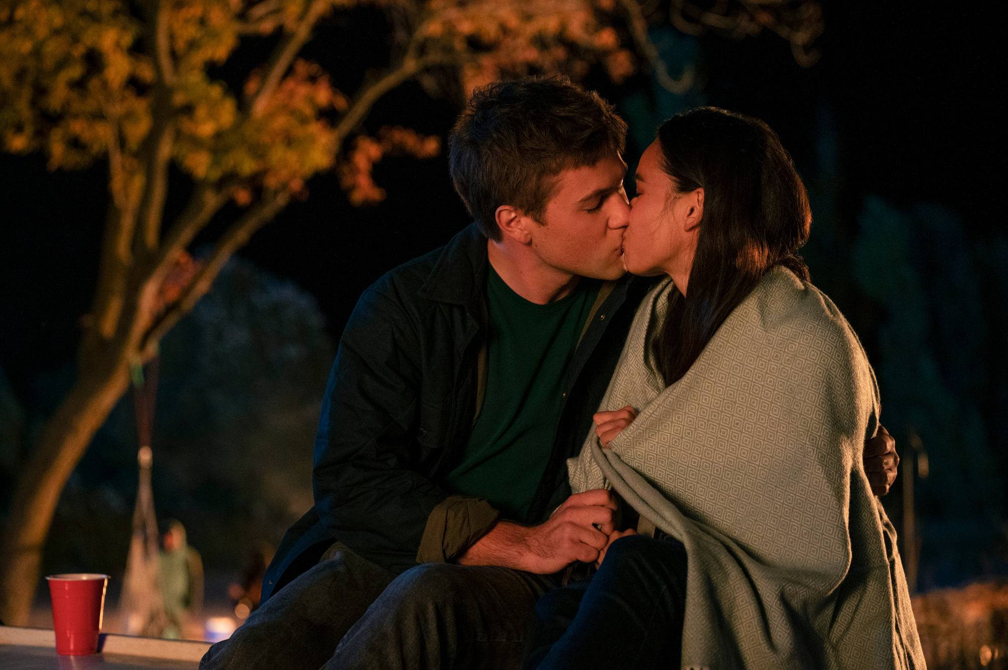 Connor Jessup and Genevieve Kang as Tyler Locke and Jackie Veda in 'Locke & Key' Season 2. They're sitting down and kissing.