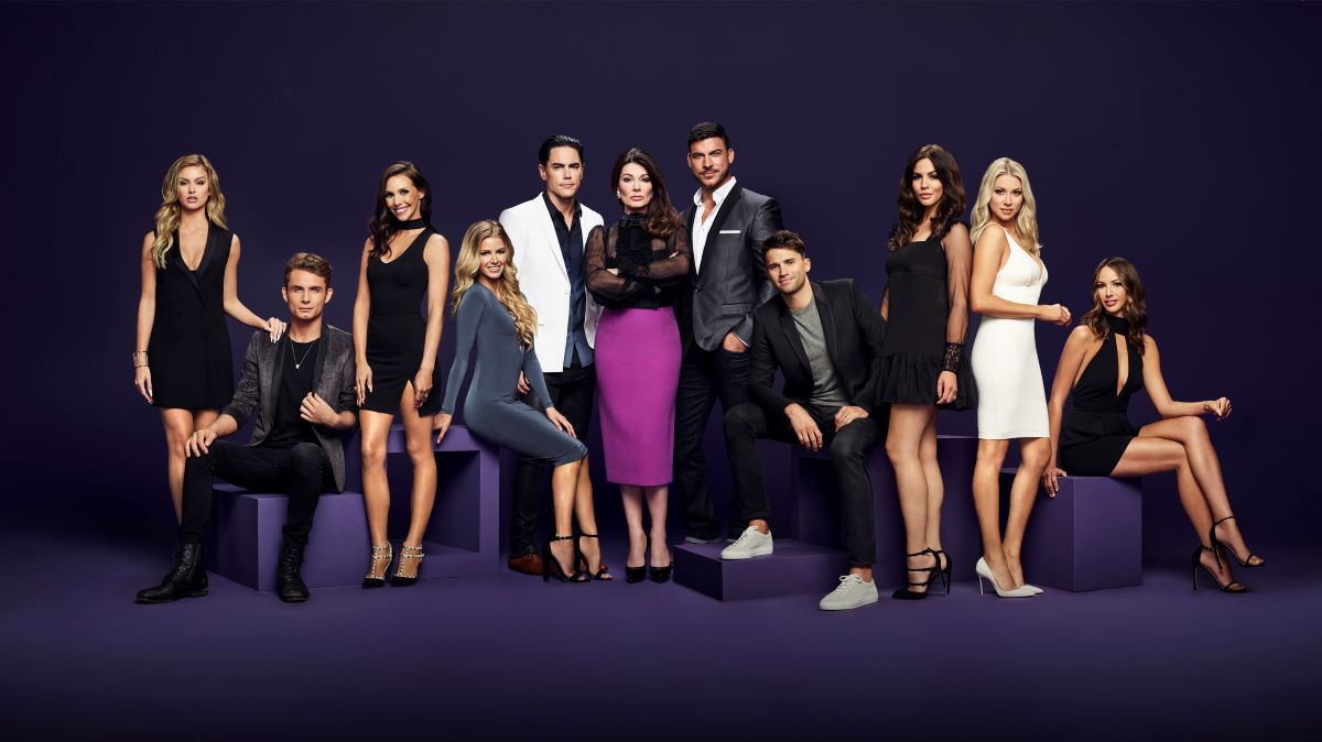 The cast of 'Vanderpump Rules' with Lisa Vanderpump at center in a black top and purple skirt.