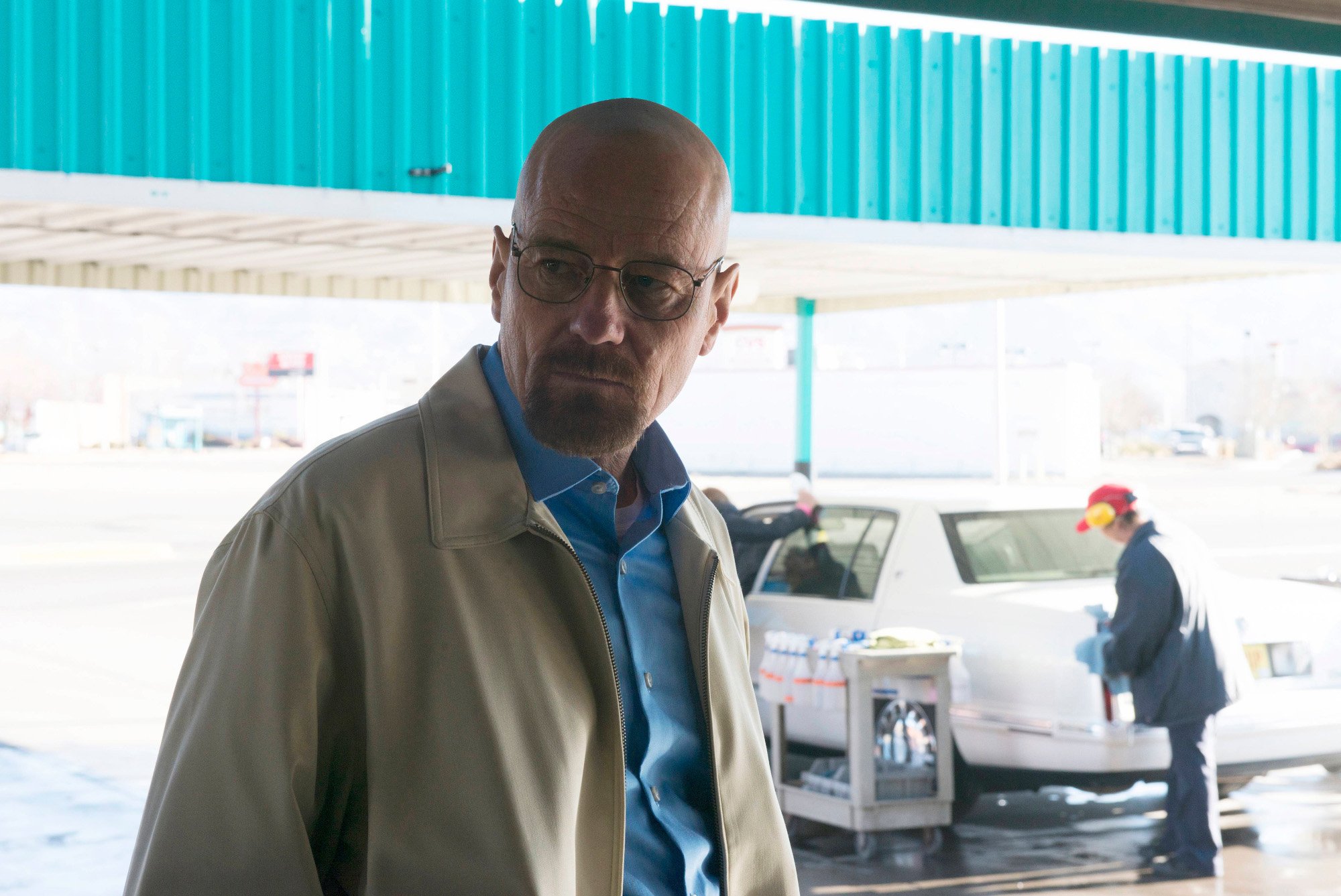 Bryan Cranston as Walter White in AMC's 'Breaking Bad.' He's wearing a blue, button-up shirt and beige jacket and looks angry.