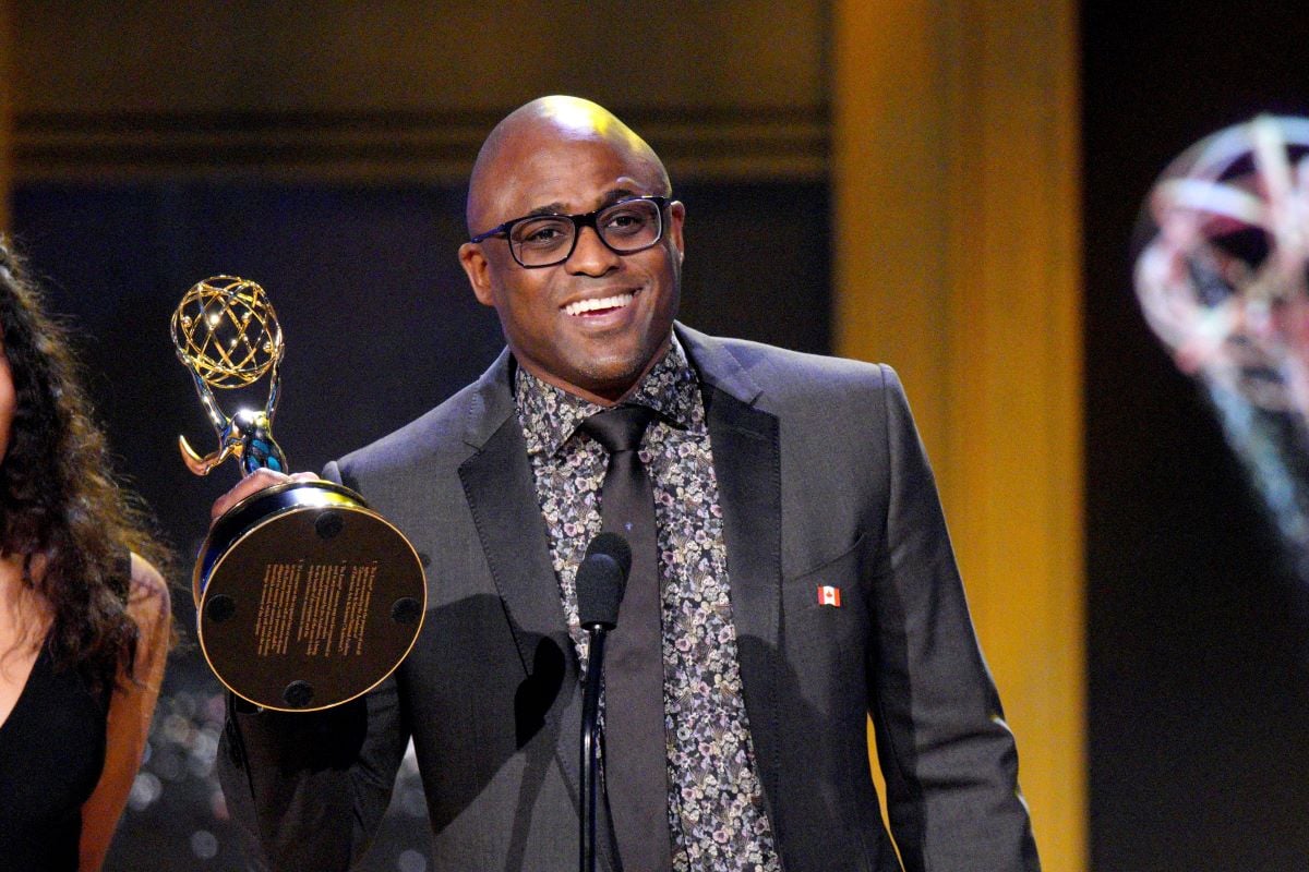 Wayne Brady smiling in glasses, holding Emmy