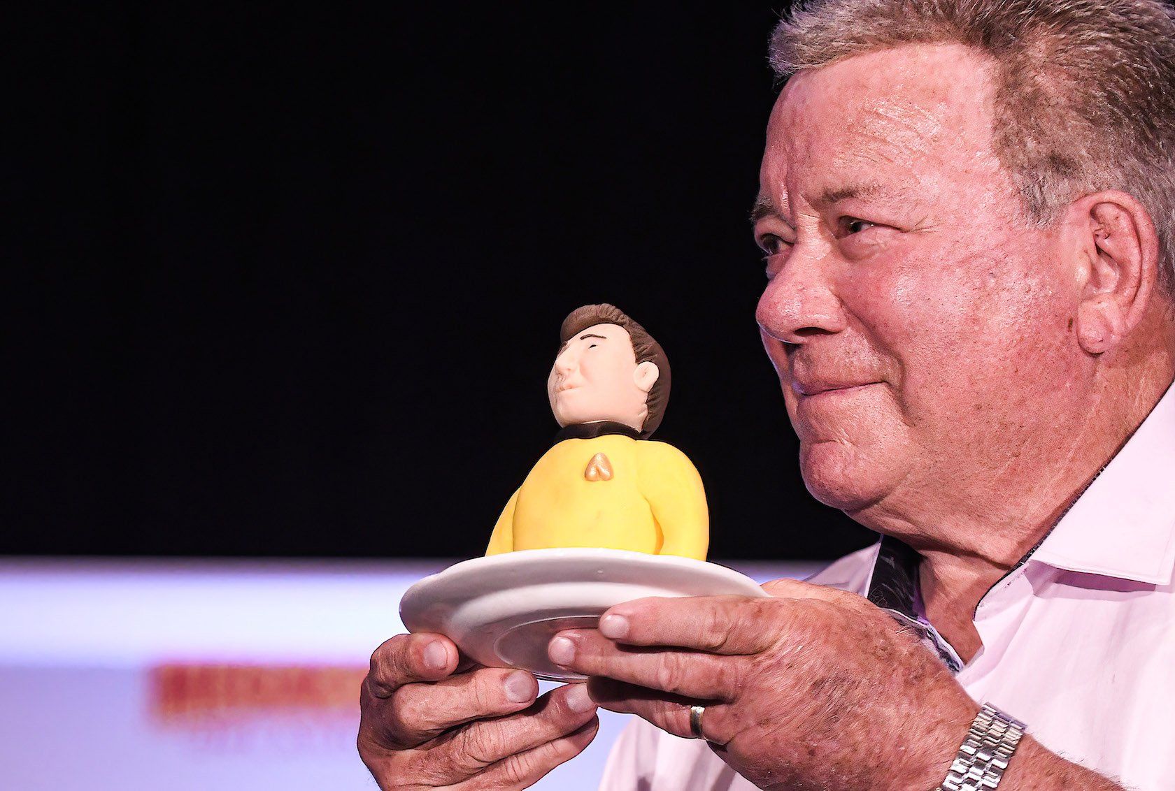 William Shatner from 'Star Trek' holds a piece of Captain Kirk birthday cake. William Shatner's age is 90 in 2021