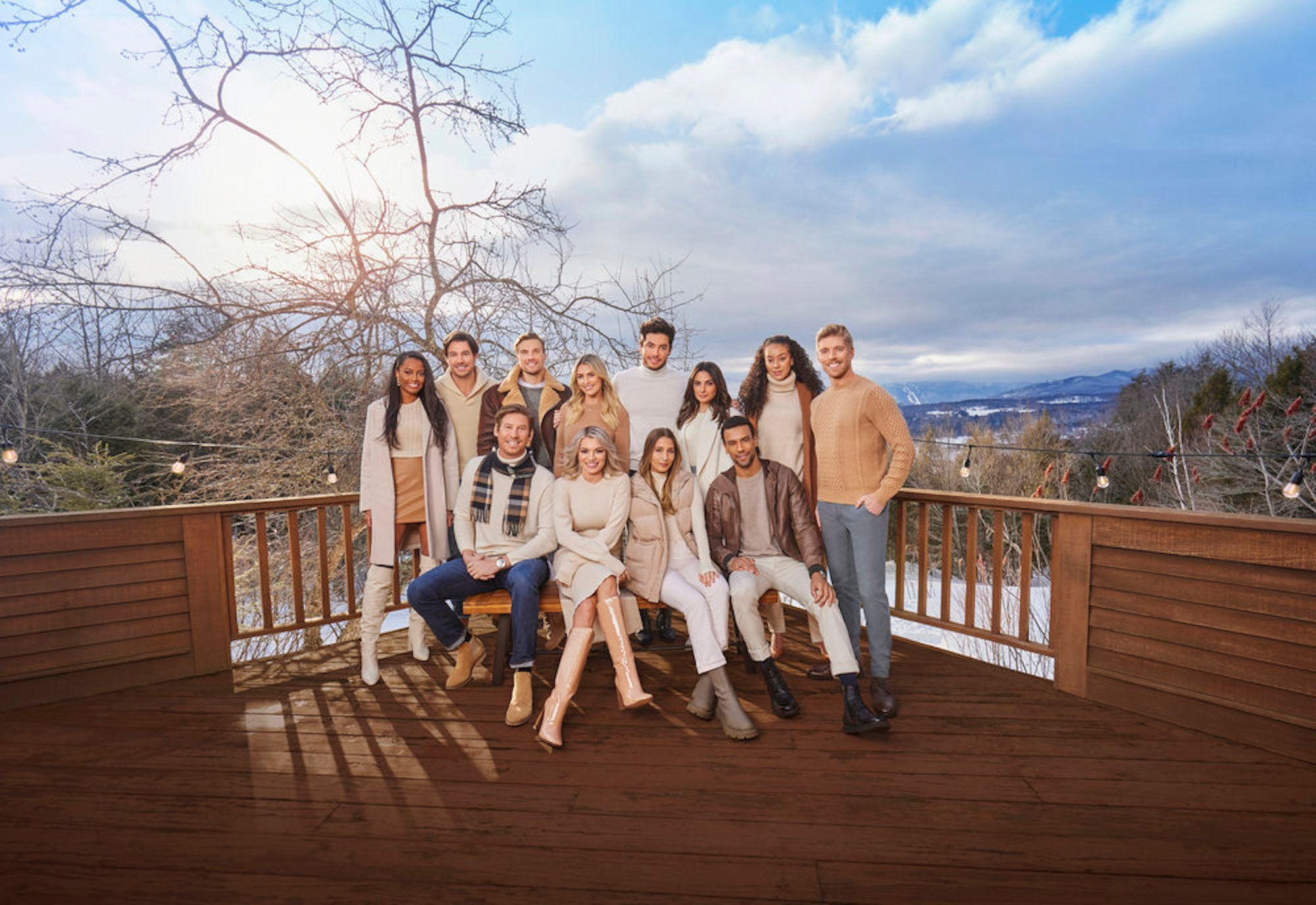 The cast of 'Winter House' pose on a balcony in front of snowy landscape in a promotional photo for 'Winter House