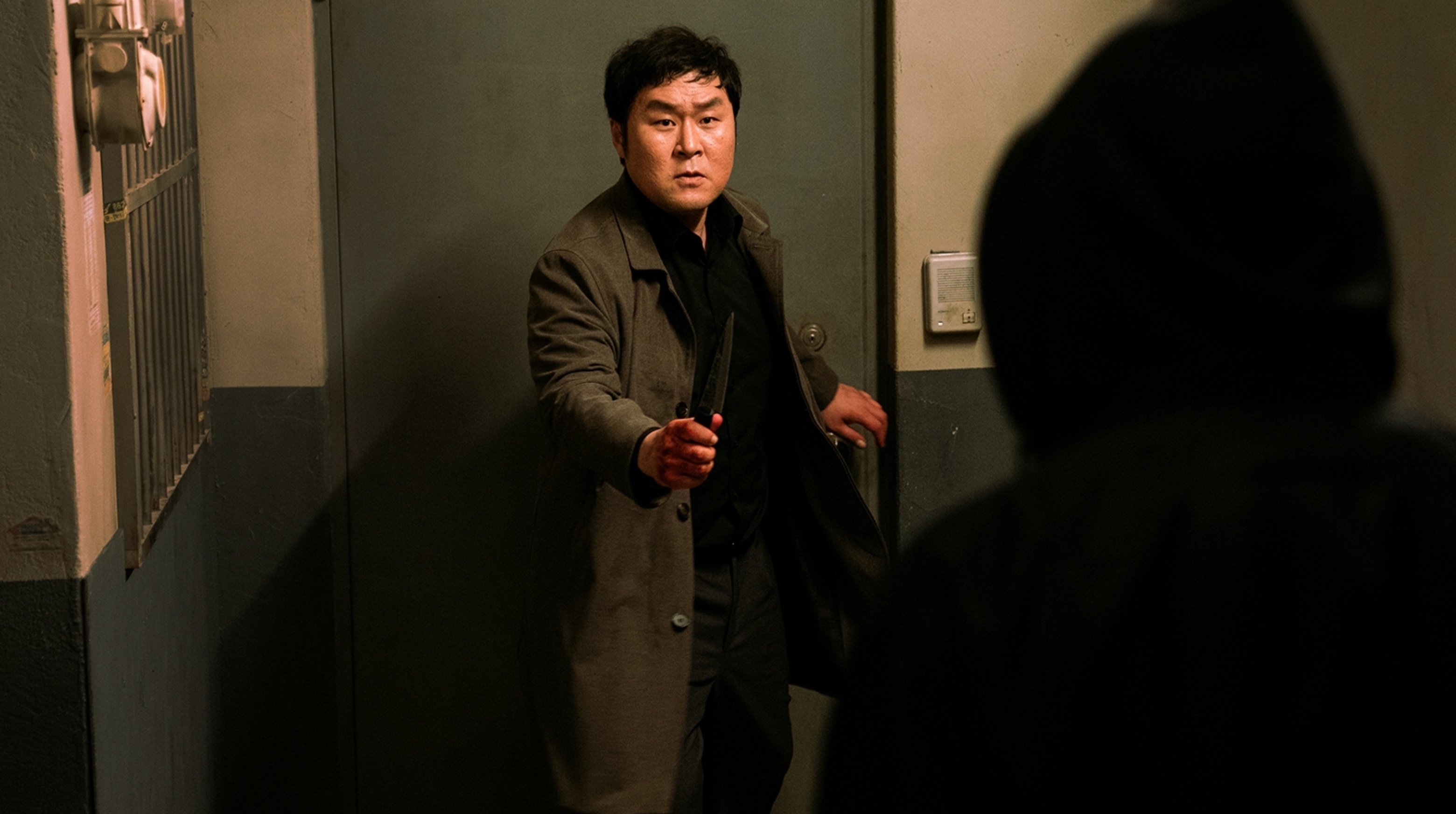 Yoon Kyung-ho as Dong-hoon in 'My Name' storyline standing in front of apartment holding knife.