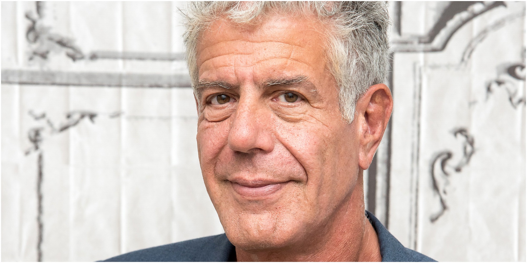Anthony Bourdain poses for a paparazzi photo on the red carpet.