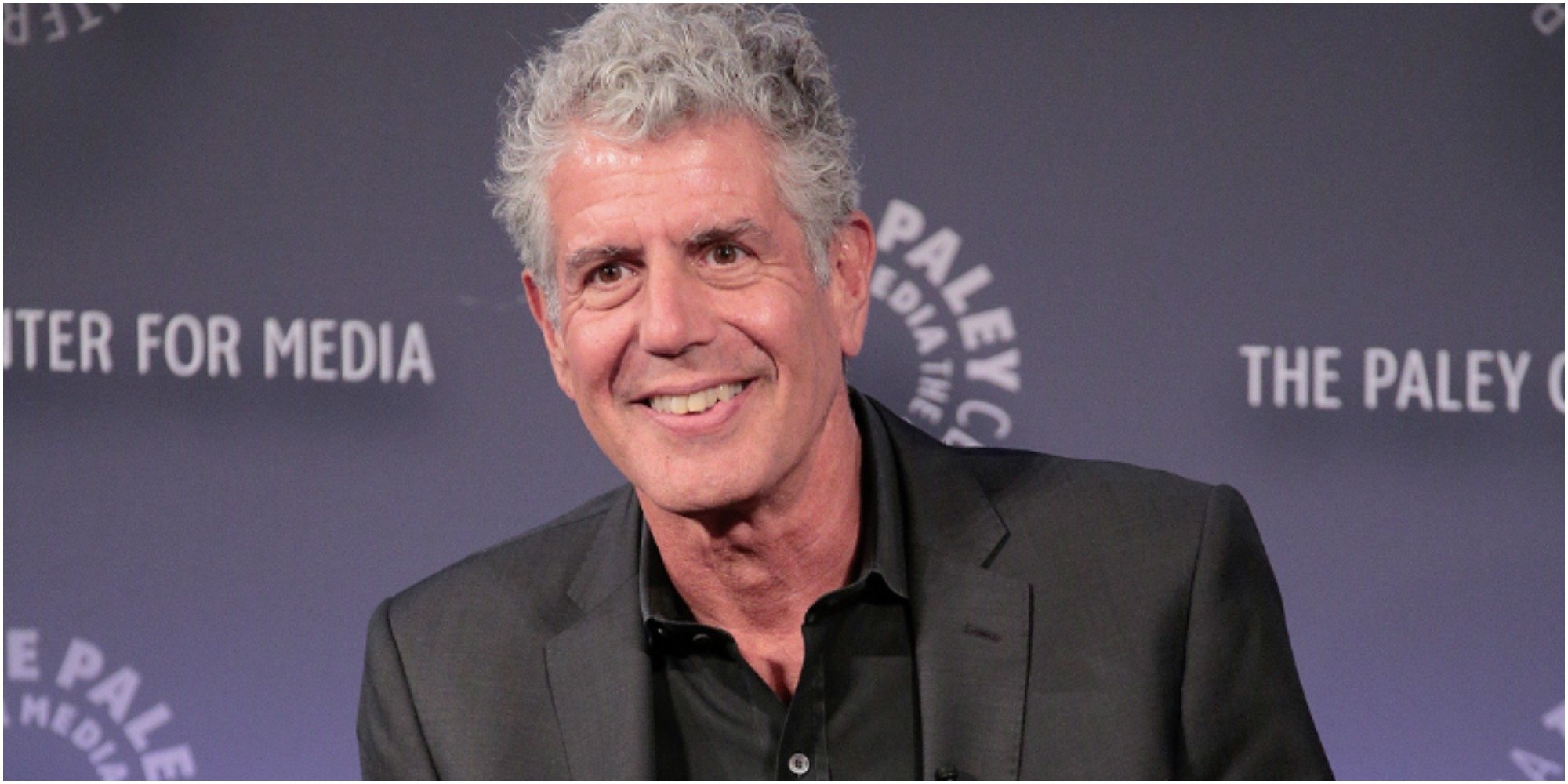 Anthony Bourdain smiles for the camera at a red carpet event.