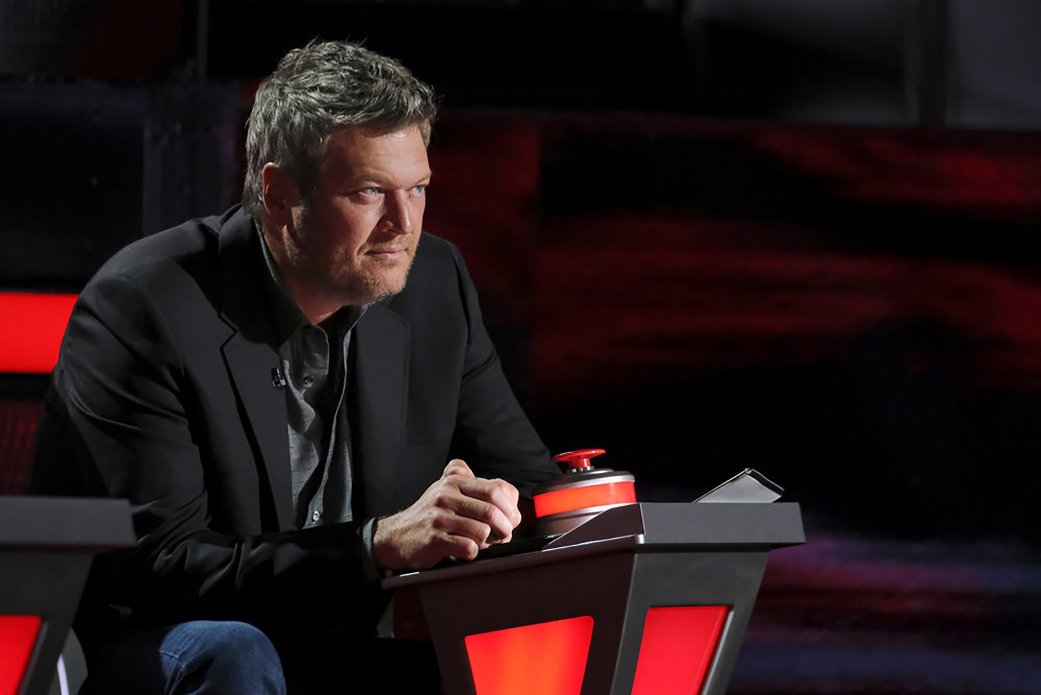 Blake Shelton sits in his coach's chair on The Voice Season 21
