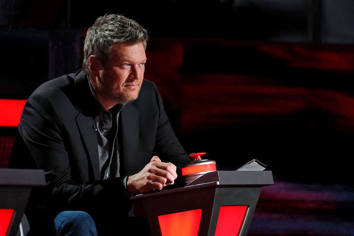 Blake Shelton sits in his coach's chair on The Voice Season 21