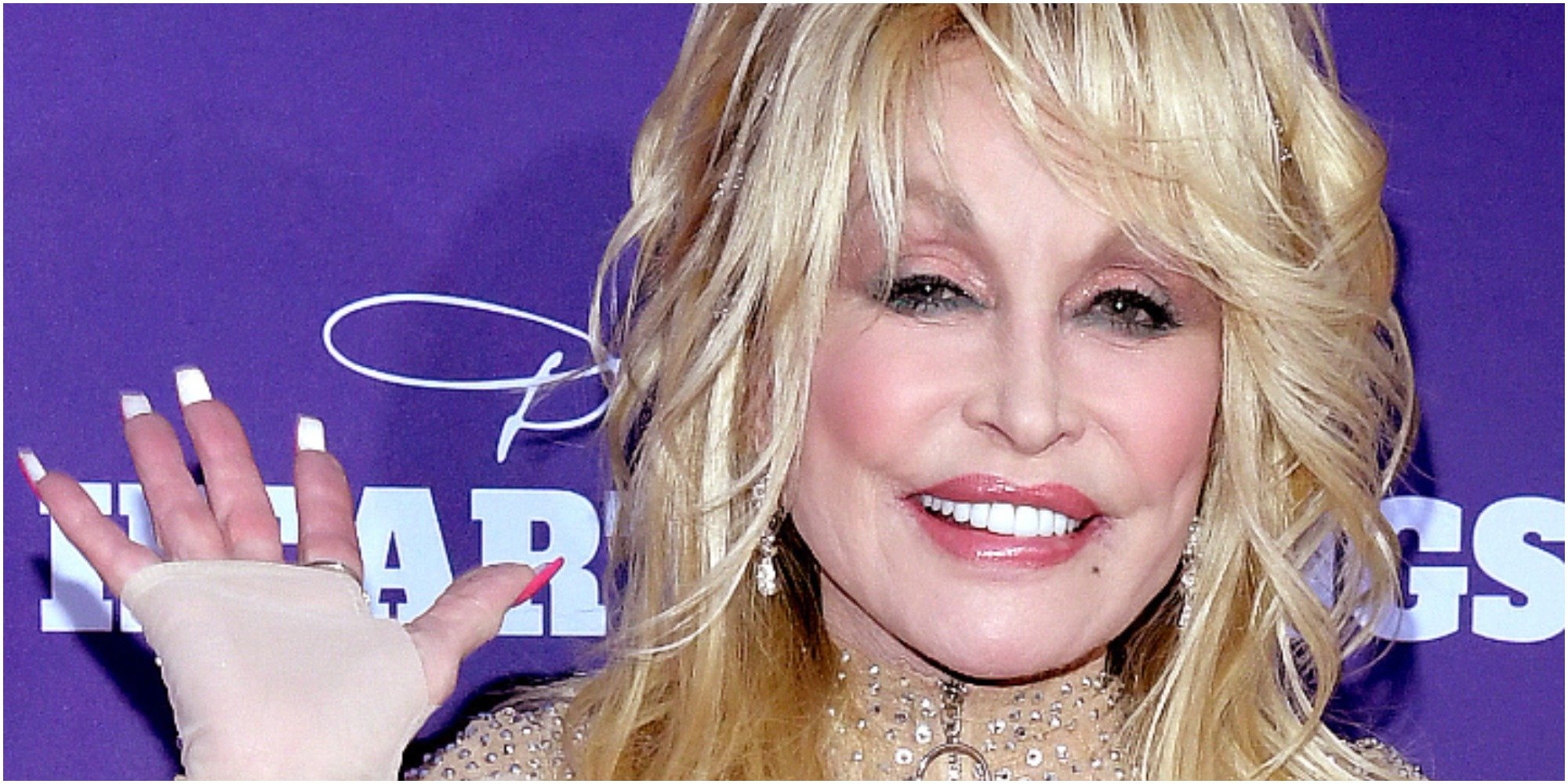 Dolly Parton waves to fans wearing a sparkly dress.