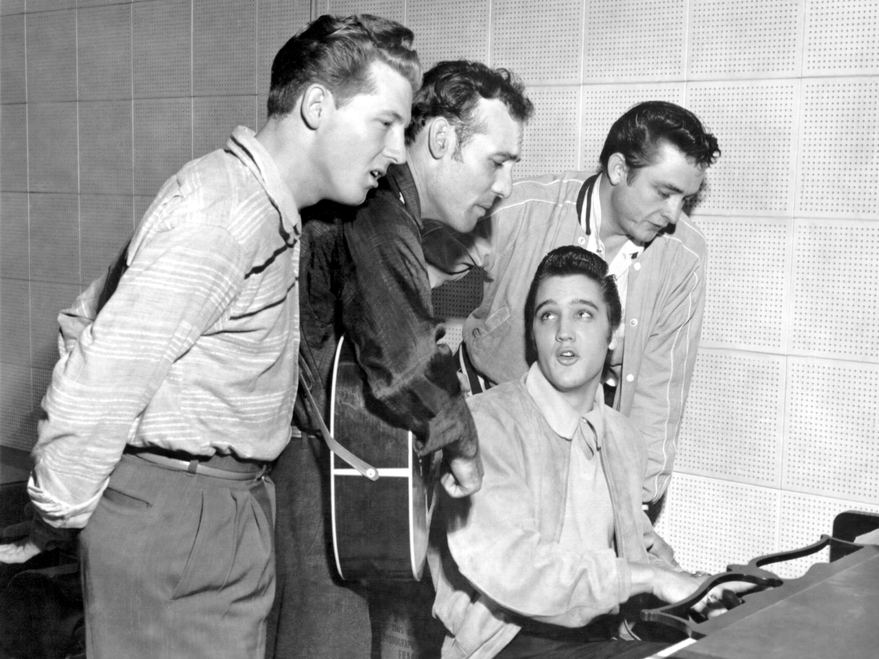 Jerry Lee Lewis, Carl Perkins, Elvis Presley. and Johnny Cash near a piano