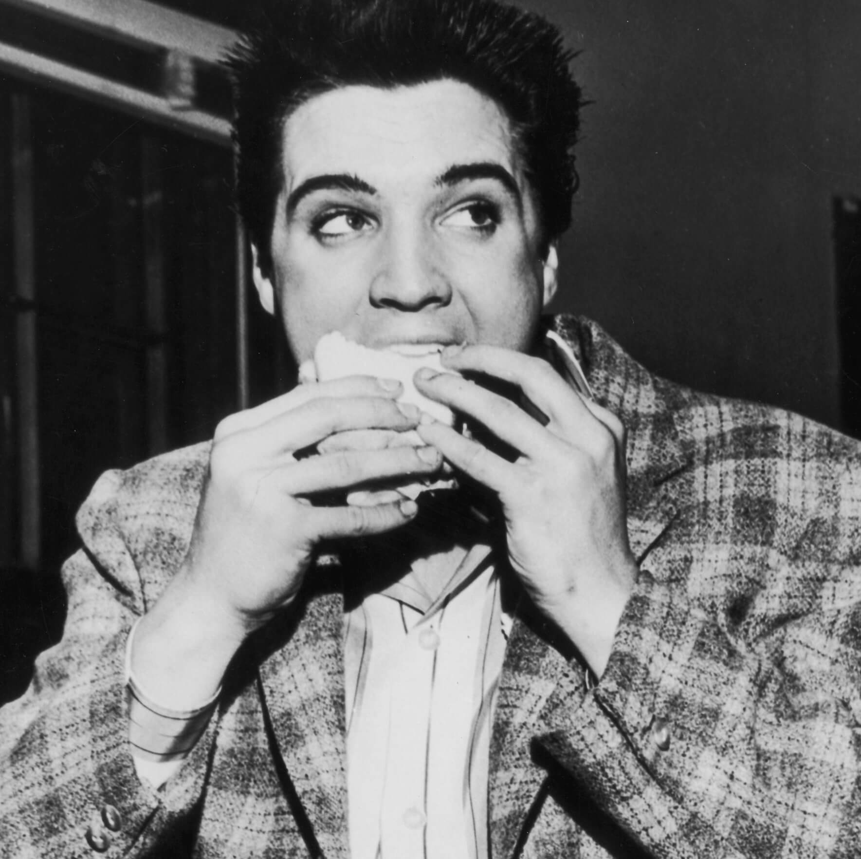 Elvis Presley eating a sandwich
