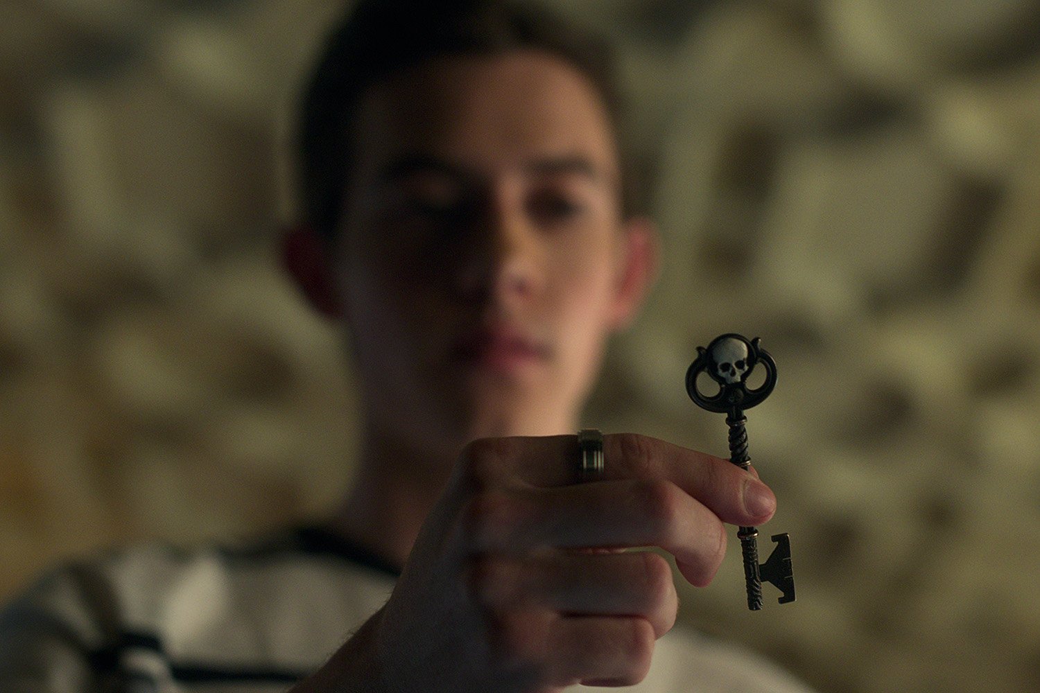 Griffin Gluck as Gabe holding a key in Locke & Key Season 2.