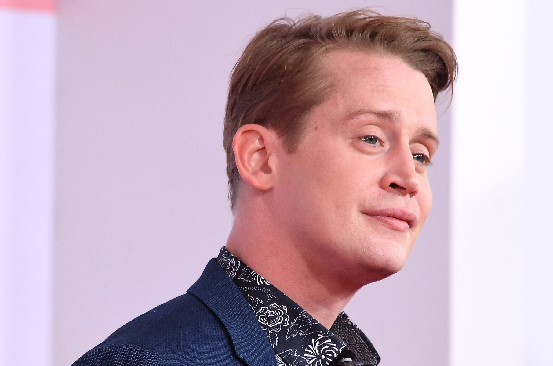 Macaulay Culkin smiles while posing at the 2018 American Music Awards