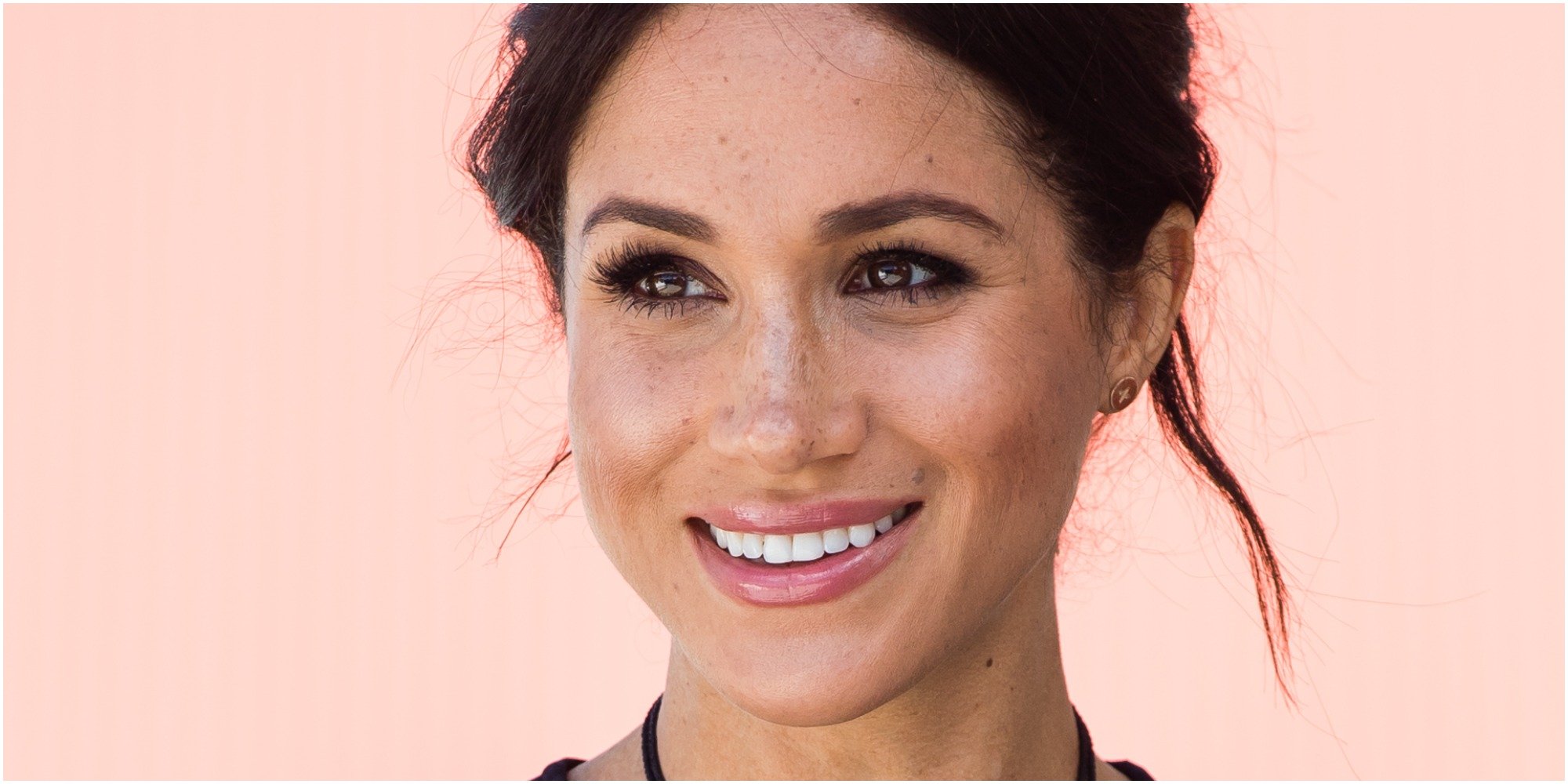 Meghan Markle smiles as she looks on