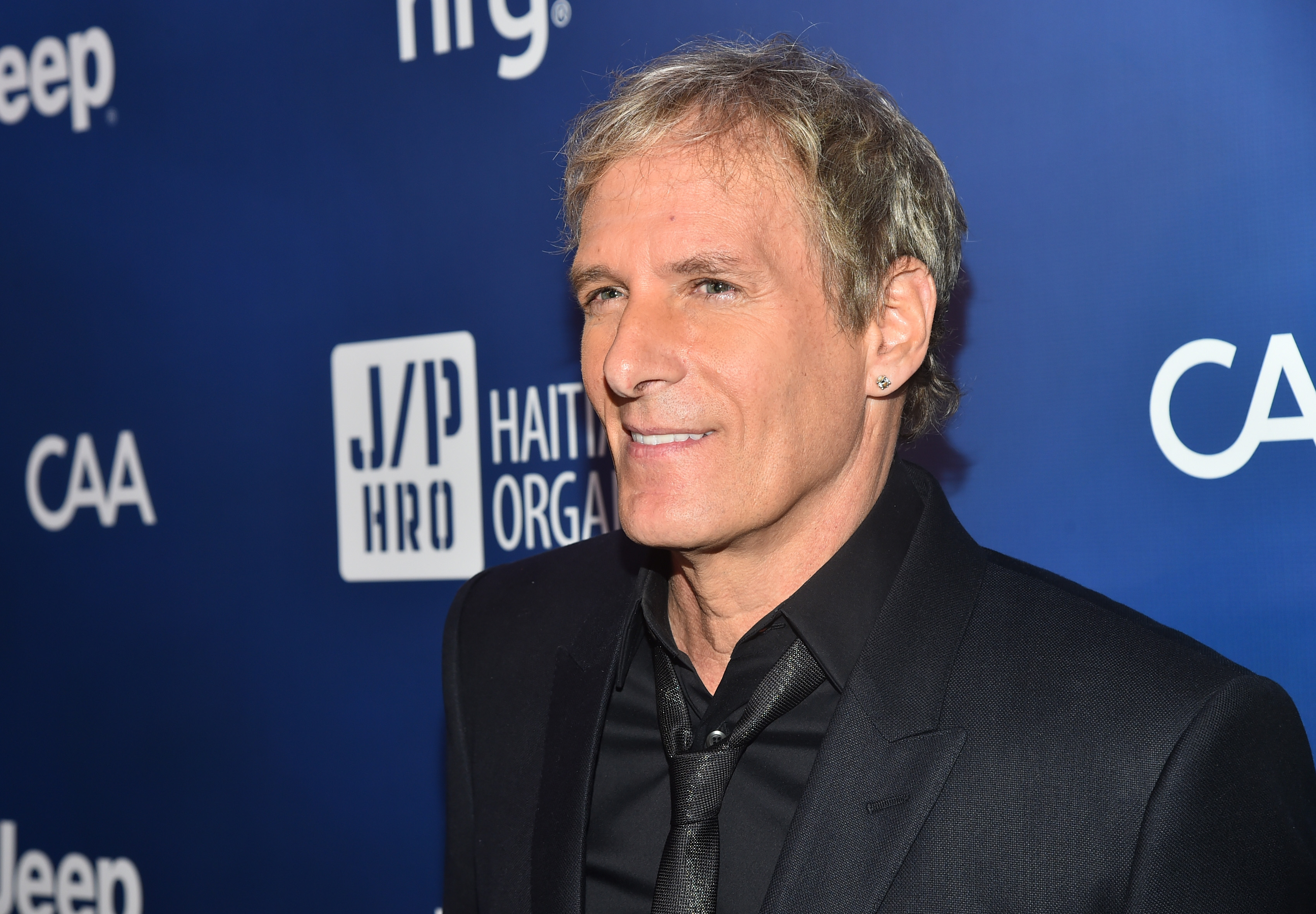 Michael Bolton wearing a black suit