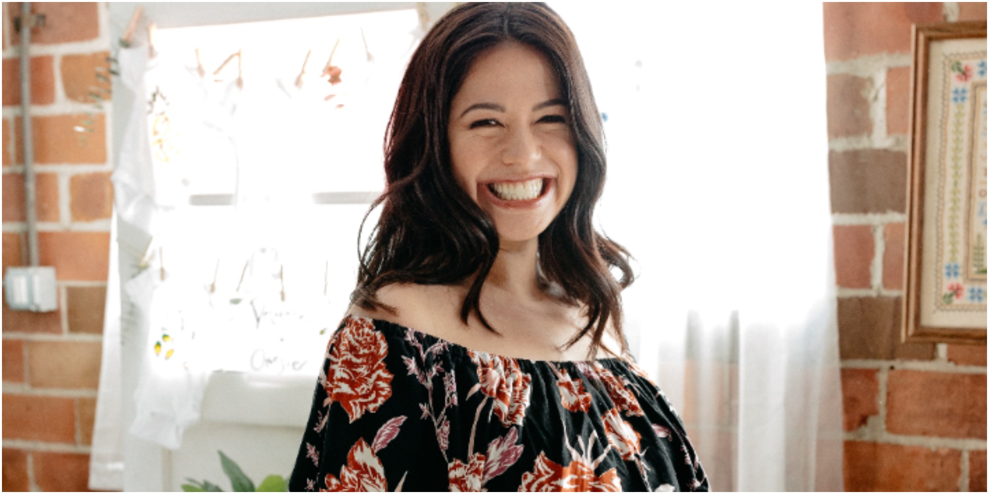 Molly Yeh wears a black dress with colored flowers in a promotional photo.
