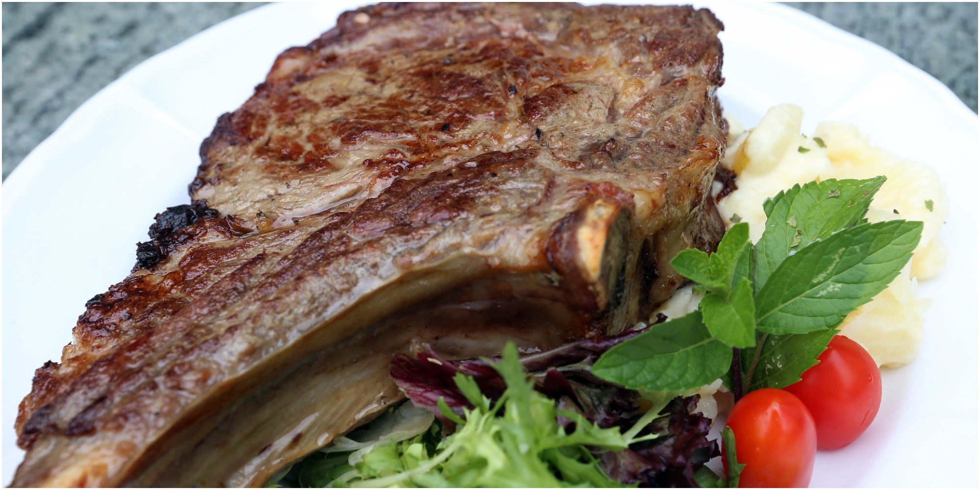 Prime rib steak served with a salad.