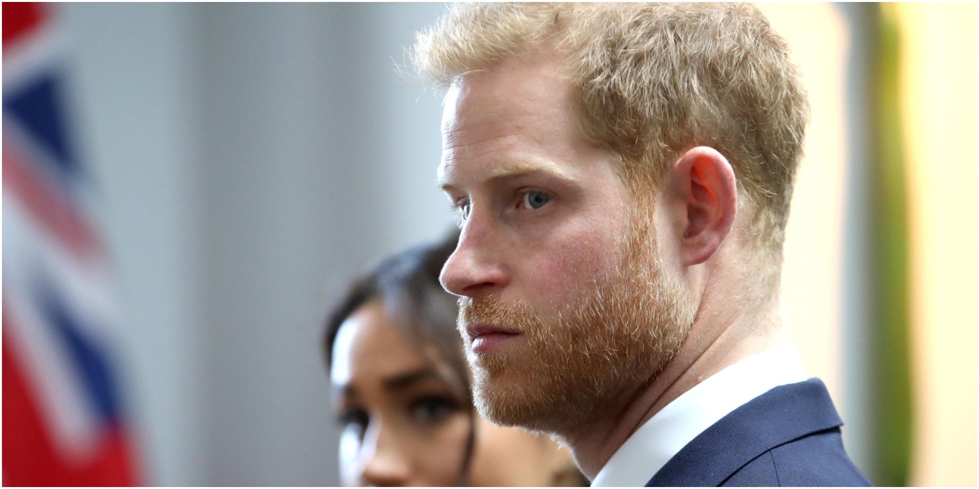 Prince Harry looks away from the camera with wife Meghan Markle.