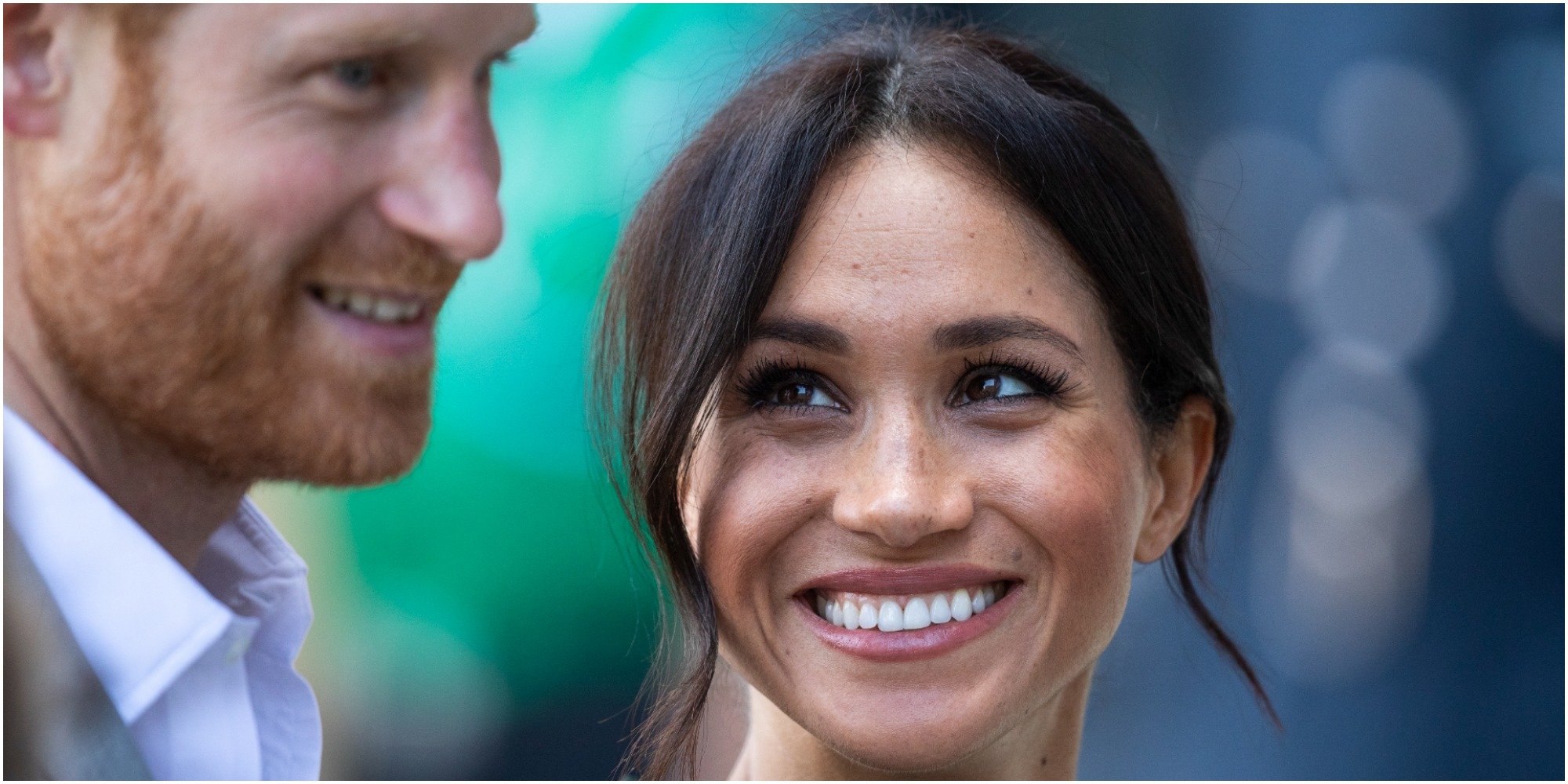 Prince Harry and Meghan Markle pose for a paparazzi photo.