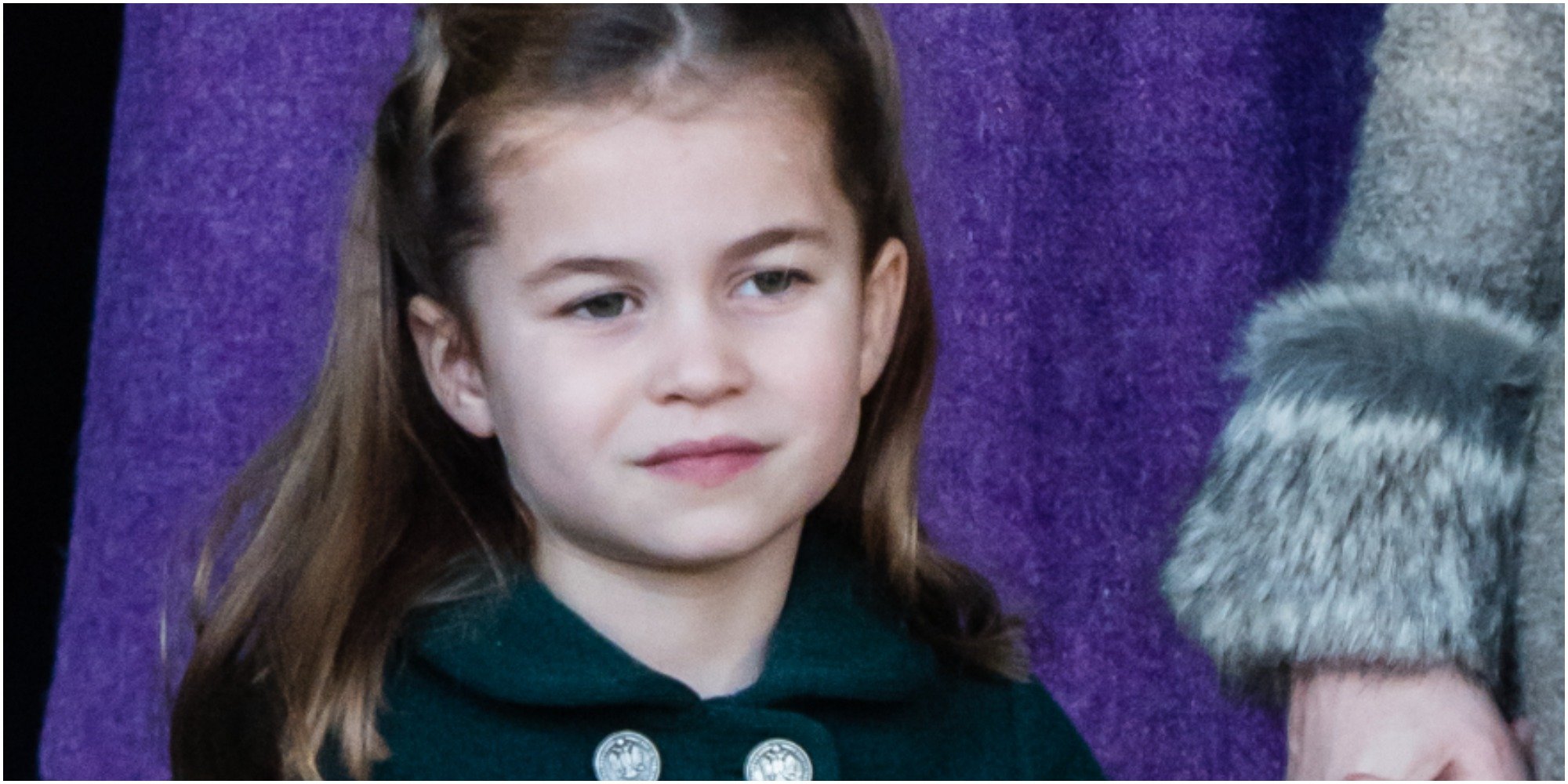 Princess Charlotte wears a green coat in a close up photo.