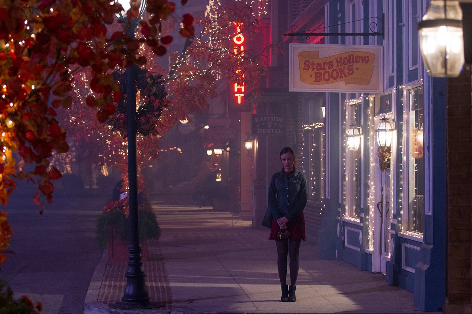 Alexis Bledel as Rory Gilmore, standing in front of Stars Hollow Books in Gilmore Girls: A Year in the Life Season 4