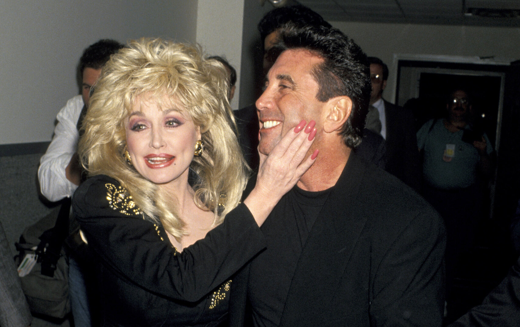 Dolly Parton grabs her manager Sandy Gallin's face.