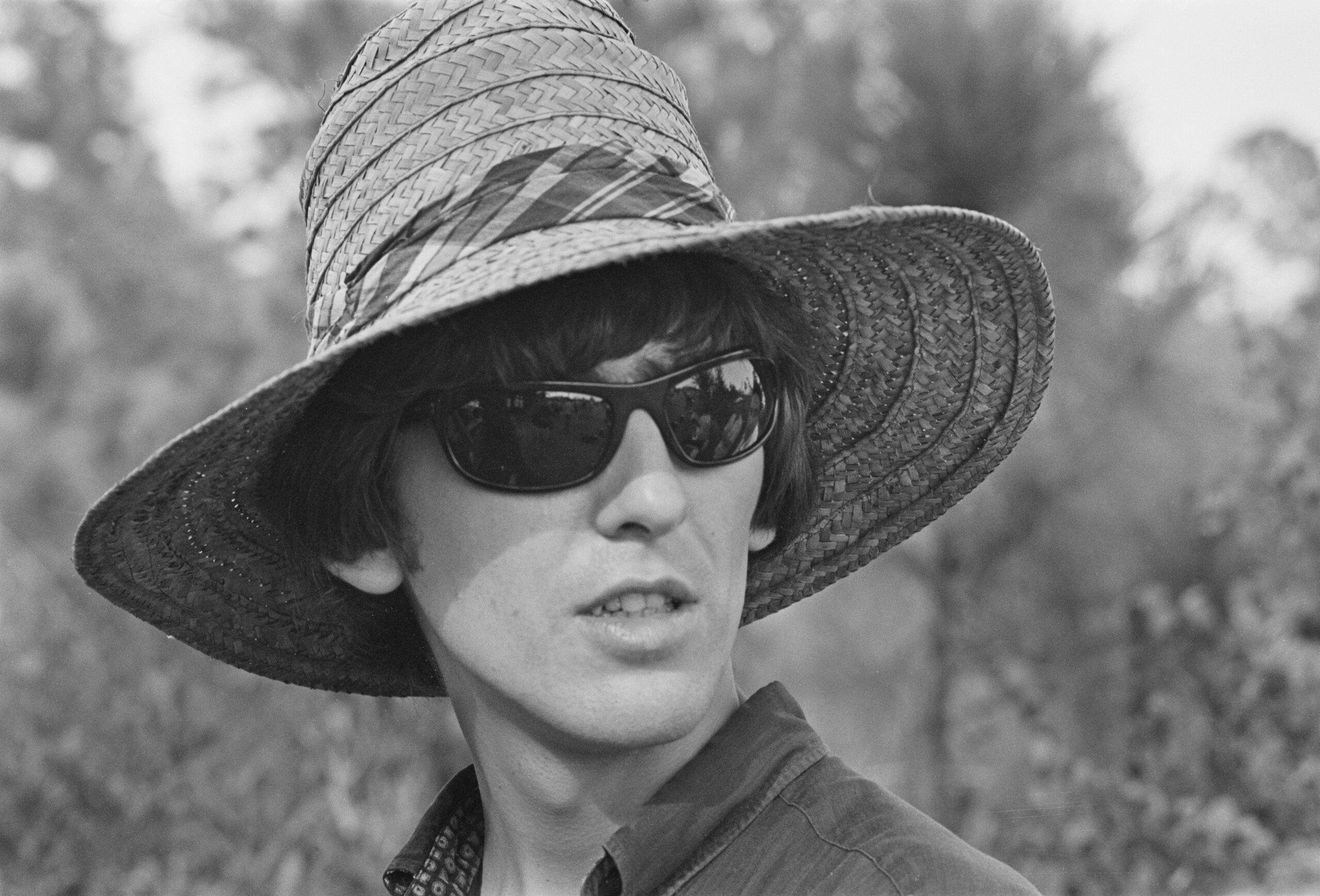 George Harrison in a straw hat and sunglasses, filming 'Help!' with The Beatles in the Bahamas.