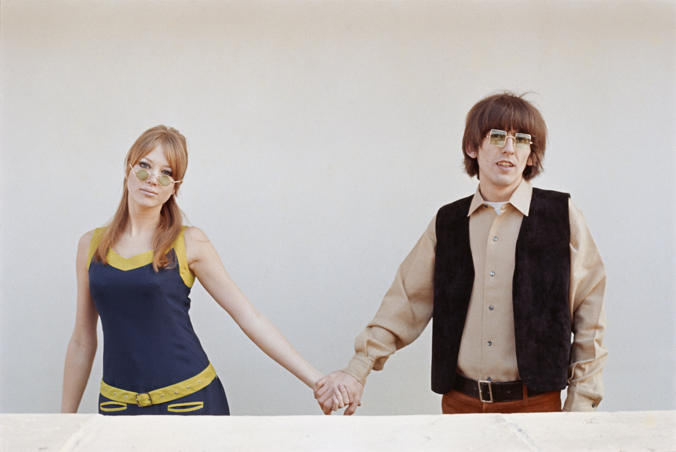 George Harrison (1943 - 2001) of The Beatles holds hands with his wife, model Pattie Boyd, circa 1970.