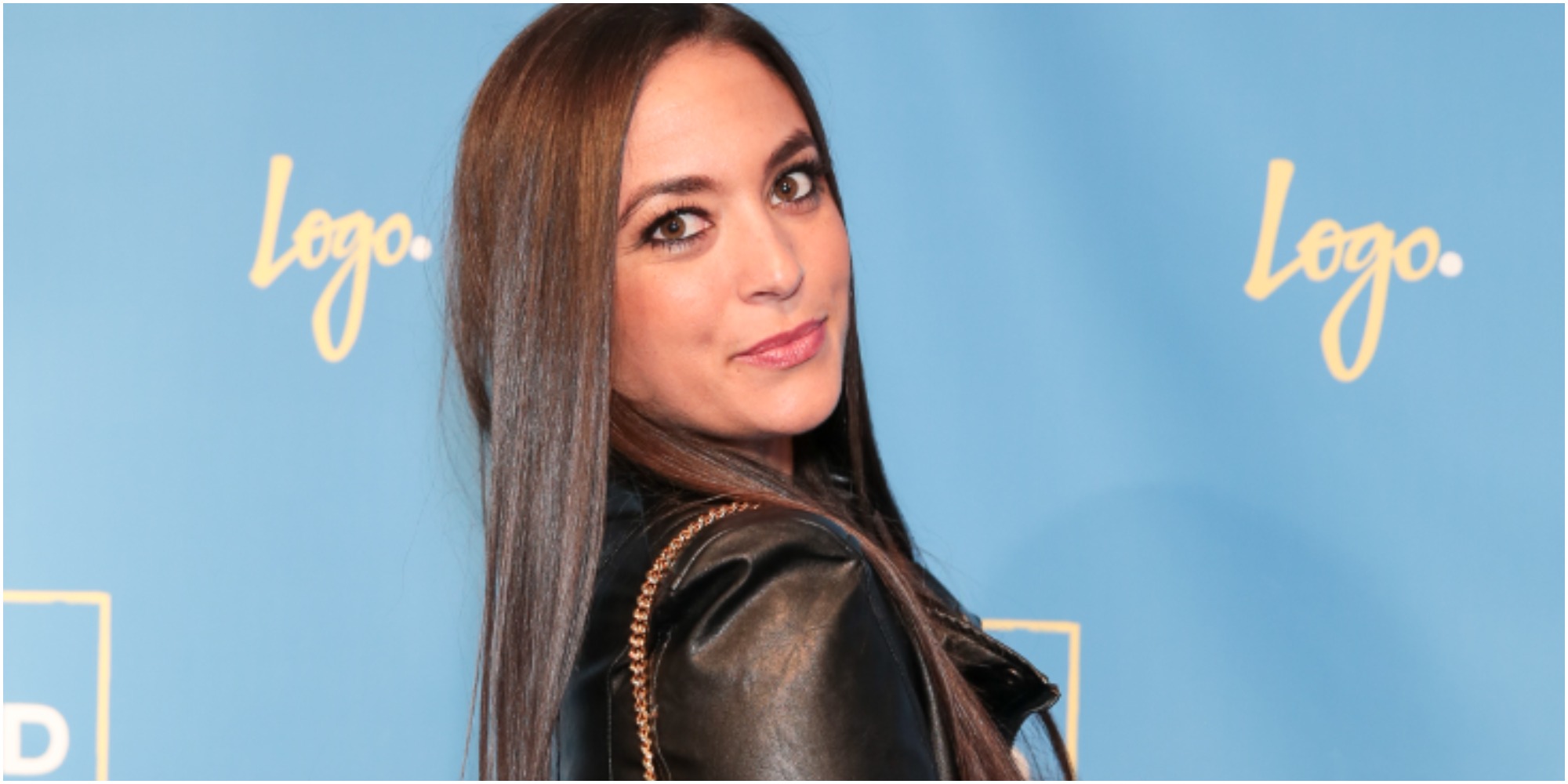 Sammi Giancola poses at a press event in a black jacket.