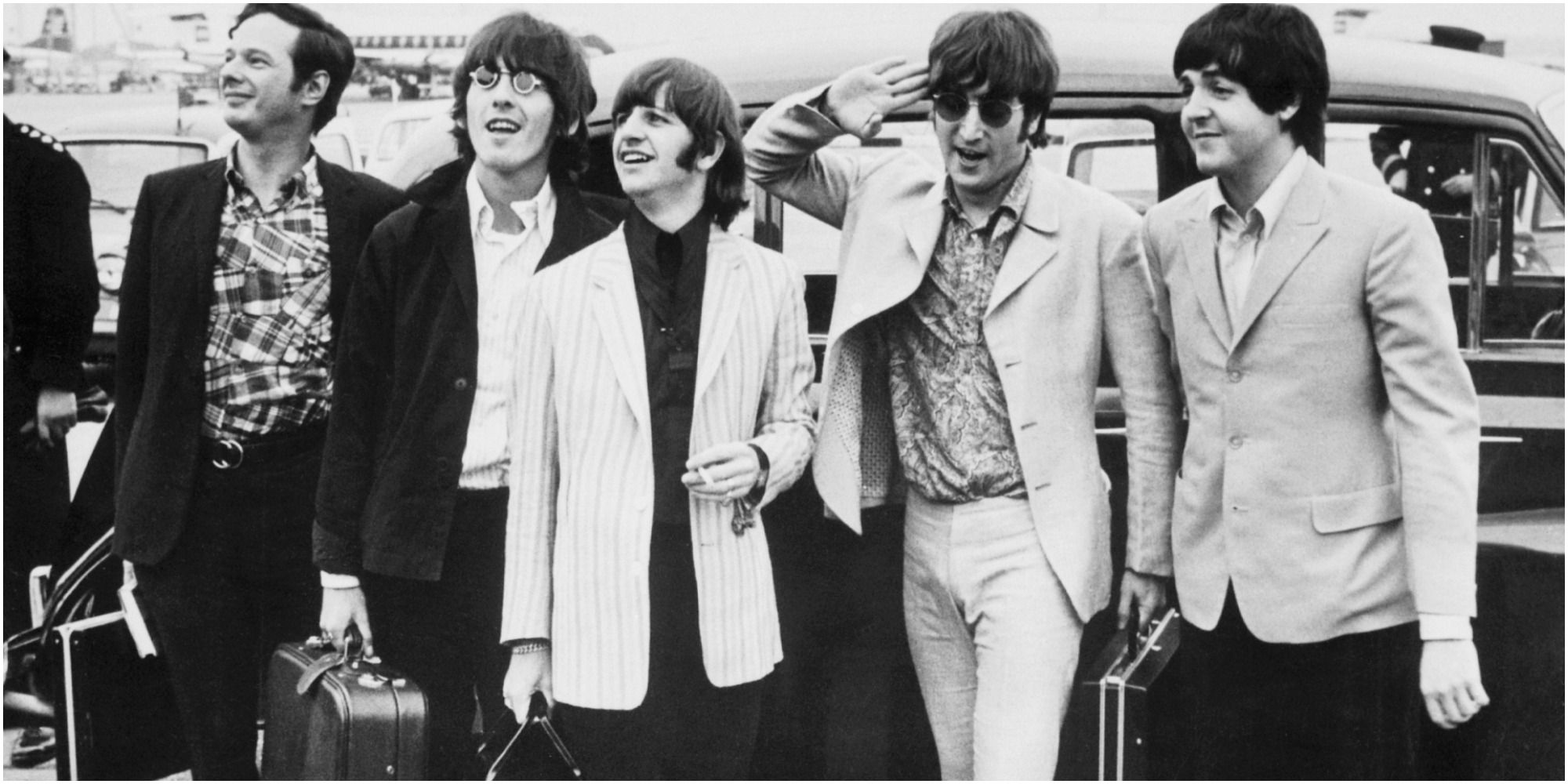 Brian Epstein and The Beatles photographed on the tarmac.