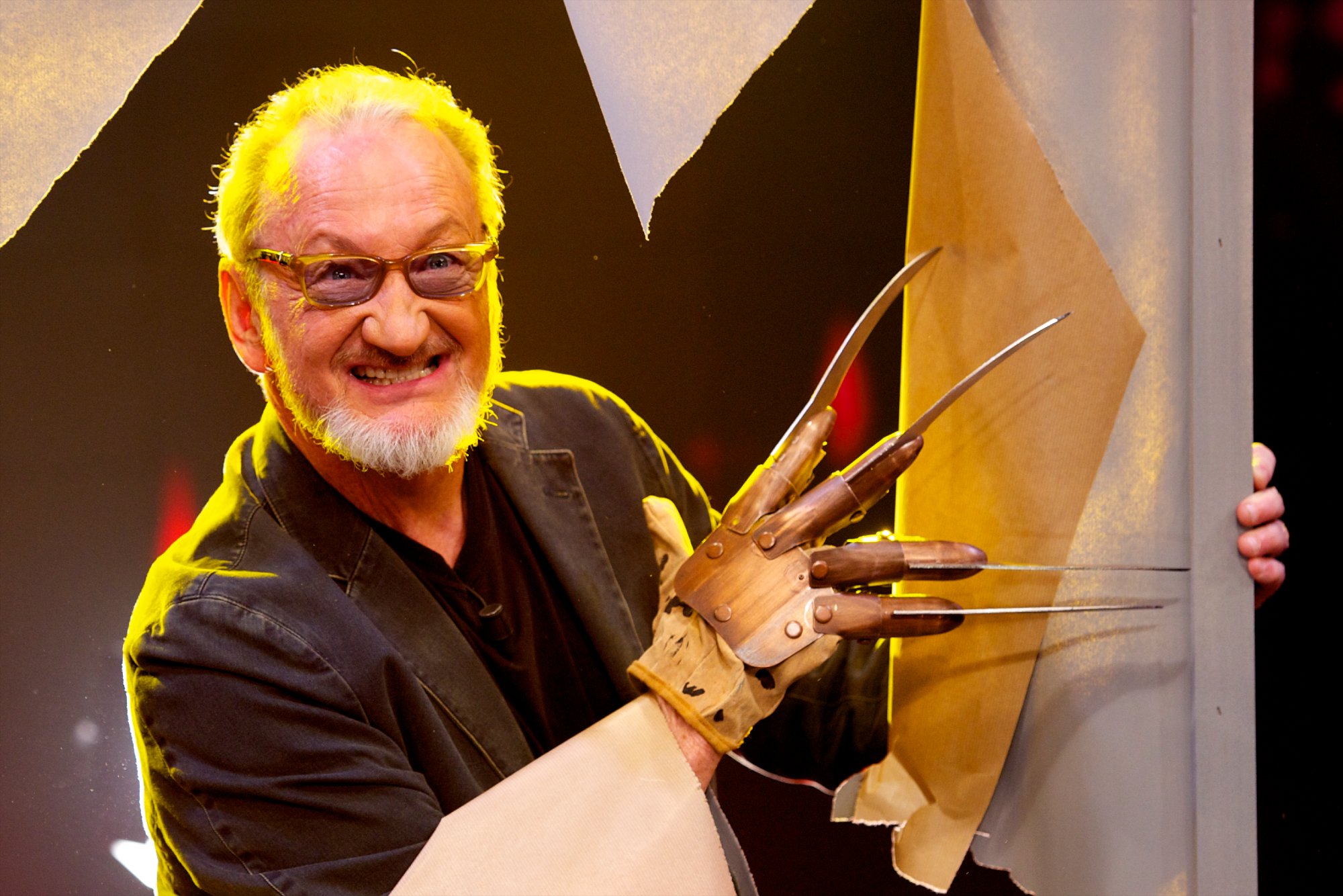 'A Nightmare on Elm Street' actor Robert Englund with Freddy Krueger glove cutting through fake wall