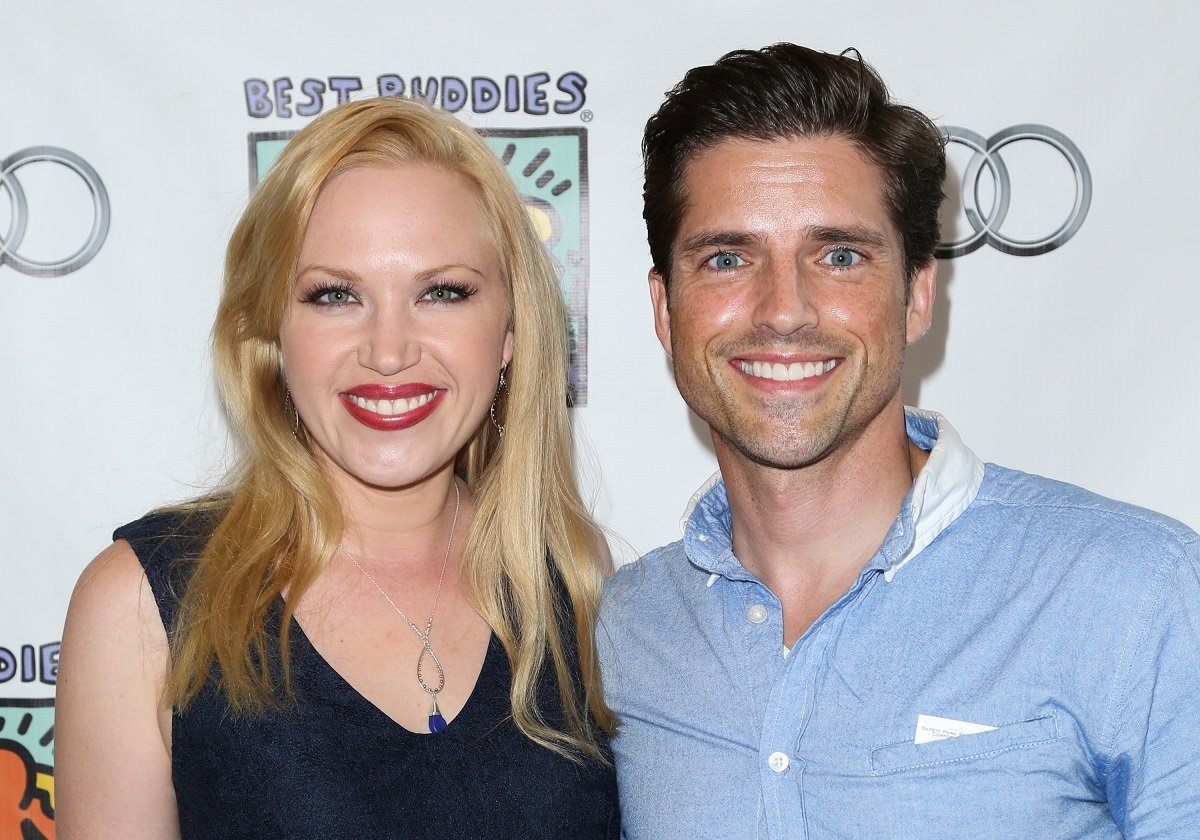 'The Bold and the Beautiful' actor Adrienne Frantz in a blue dress, and her husband Scott Bailey wearing a blue and white shirt; pose for a photo.