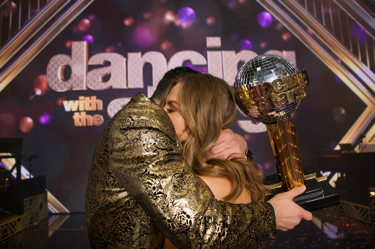 Alan Bersten and Hannah Brown, the 'Dancing with the Stars' winners of season 28, embrace holding the Mirrorball trophy