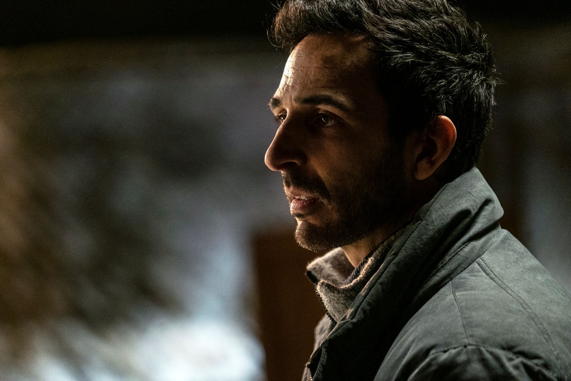 'The Blacklist' star Amir Arison, in character as Aram Mojtabai, wears a grayish green jacket.