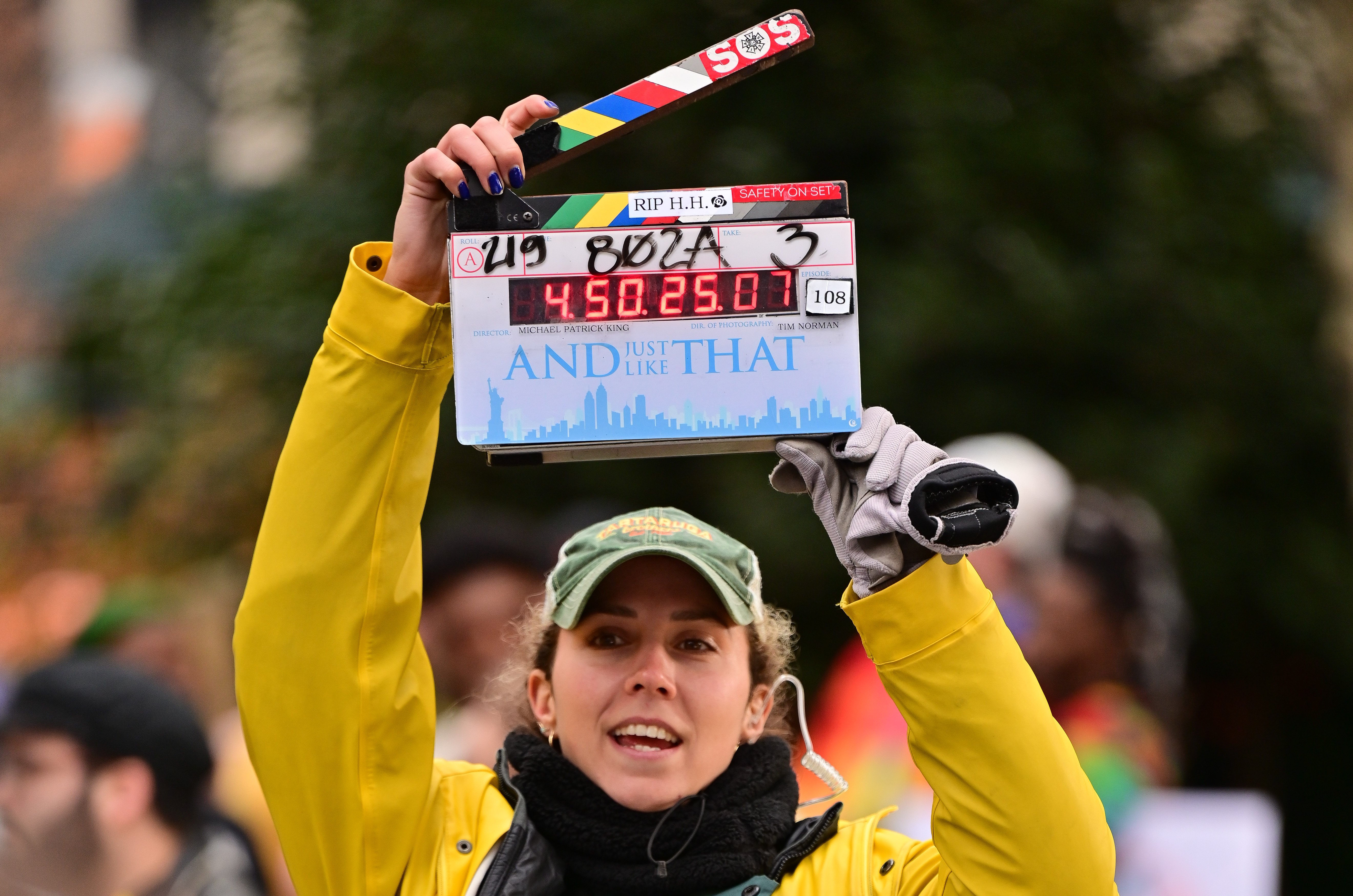 A production team member holds up a clapperboard on the set of 'And Just Like That...'